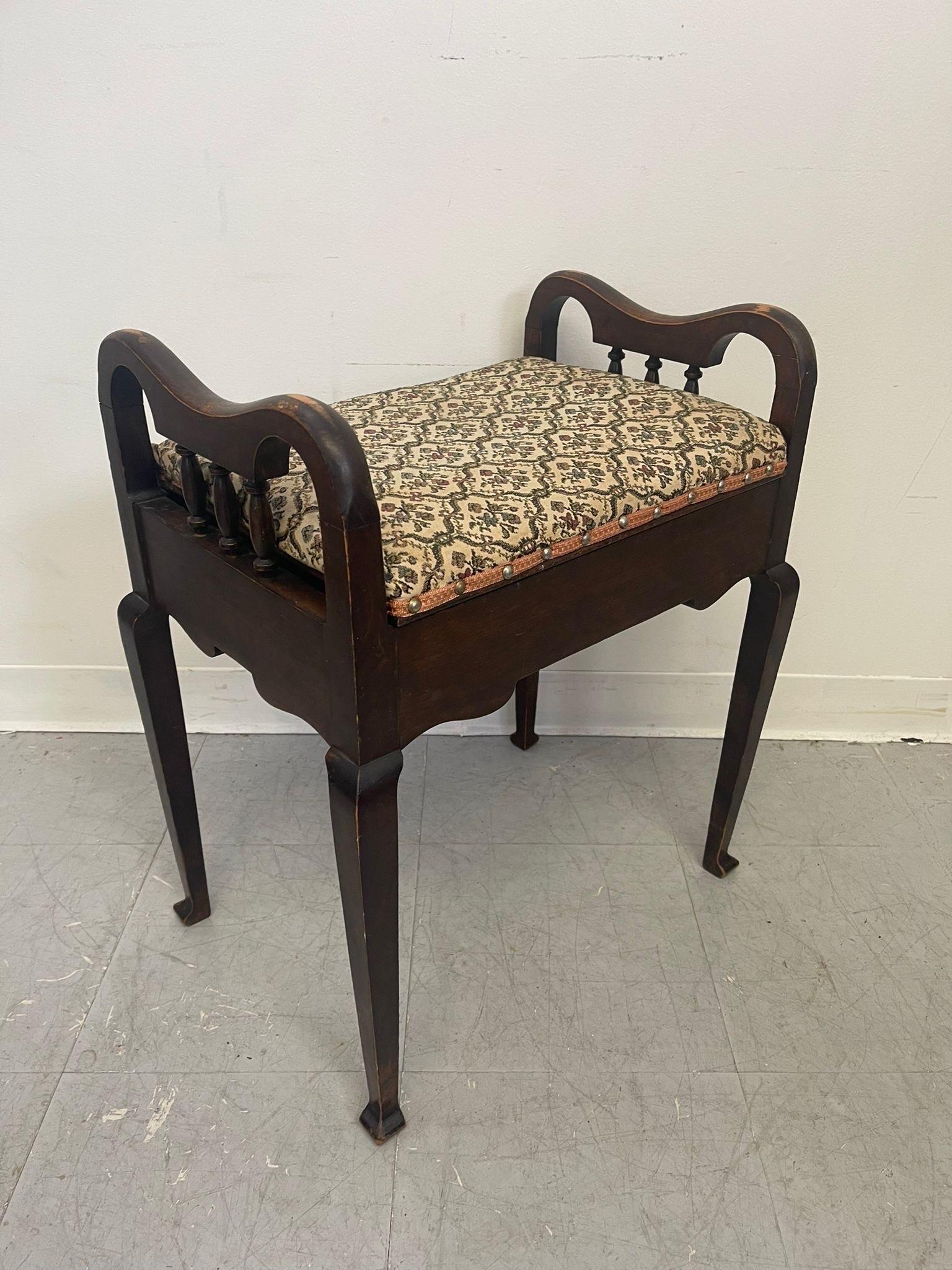 This Stool has beautiful carved detailing and Aging to the wood. The Upholstery has a stunning floral pattern. The seat lifts up to reveal a storage compartment. Vintage Condition Consistent with Age as Pictured.

Dimensions. 21 W ; 14 D ; 24 H