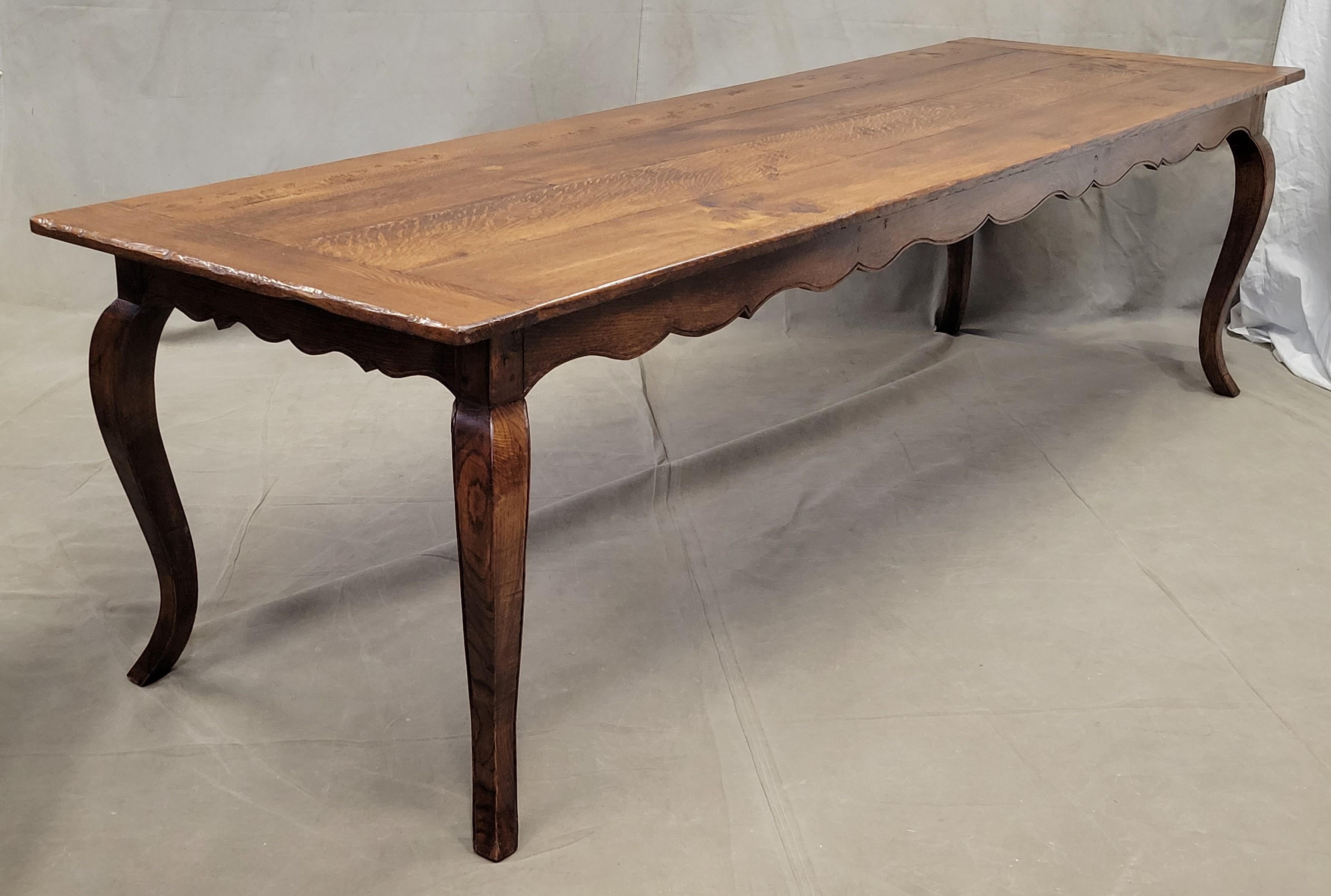 A monumental, elegant vintage custom-made 9' long French oak farmhouse dining table with Louis XV lines. An absolutely gorgeous hand-made table created (likely in the 1990s) out of old lumber that seats 10 comfortably. A perfect blend of rustic,