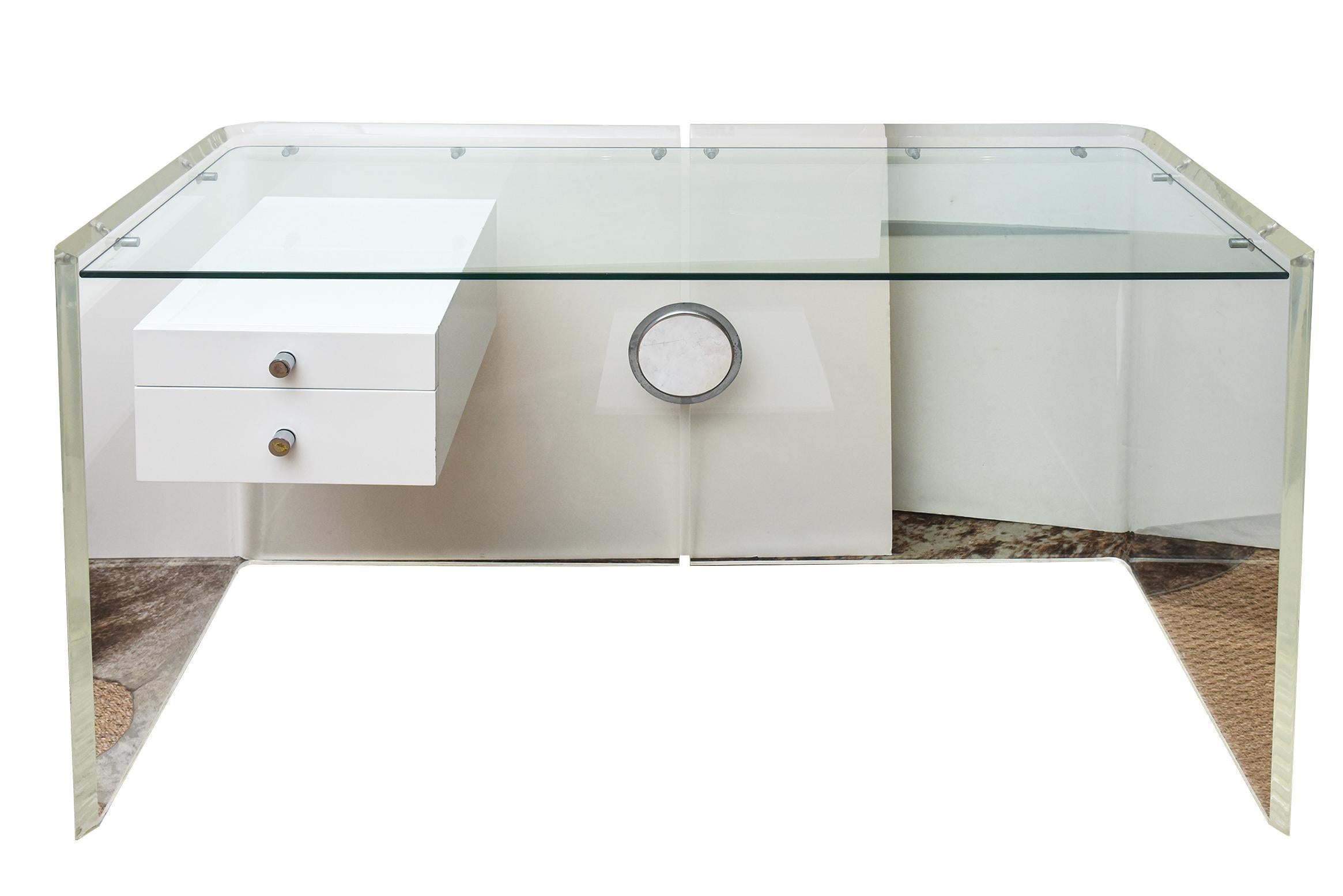Este increíble escritorio flotante vintage hecho a medida, con 2 cajones lacados en blanco y tiradores redondos cromados, tiene una tapa de cristal empotrada que flota sobre clavijas de acero alrededor de todo el escritorio.
Los laterales de lucita