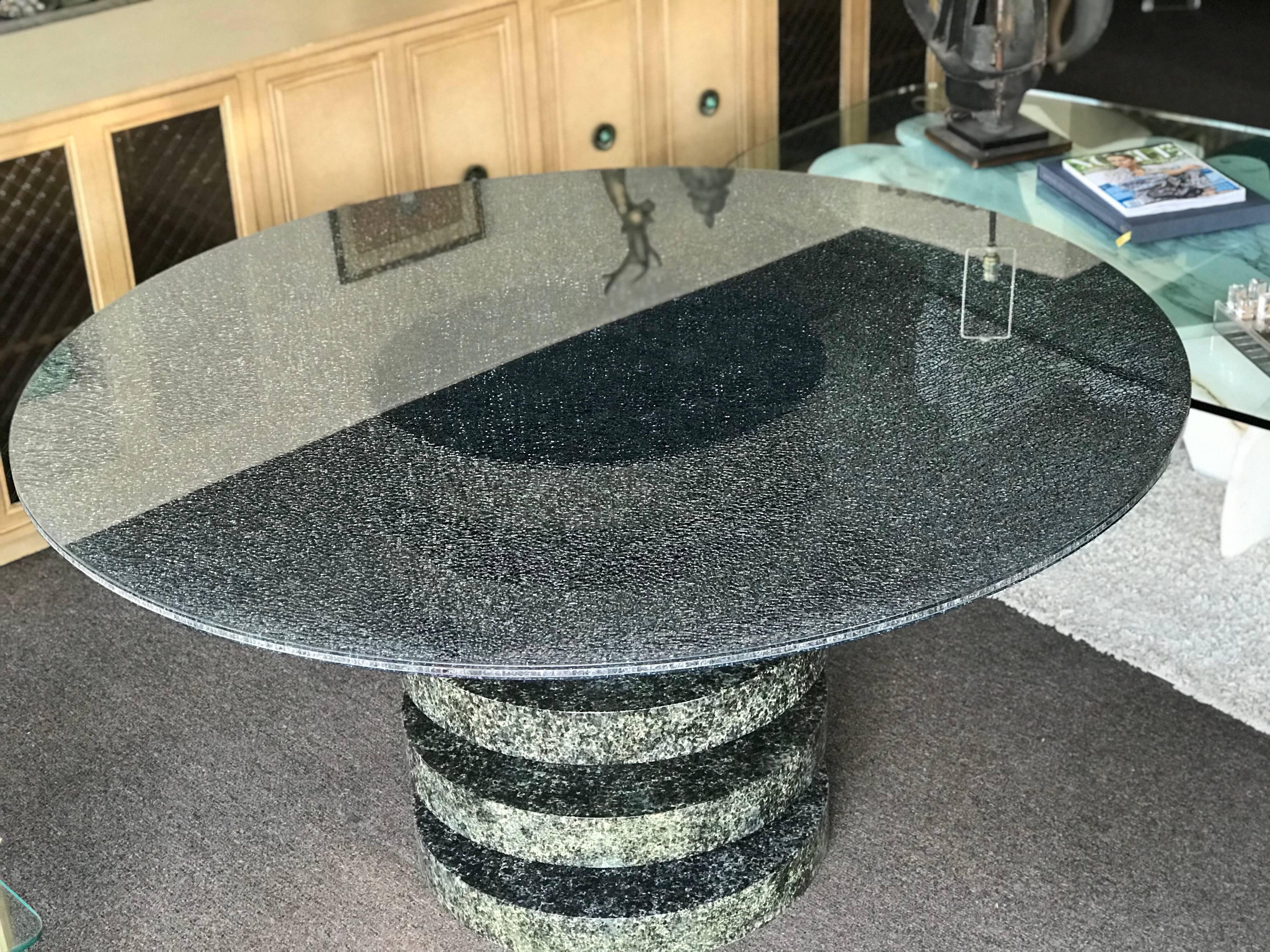 This custom-made table is the most beautiful, modern dining table we have ever had in the store. Custom made for a extremely upscale Palm Springs Area Country Club Estate. The top is a three layer smoke grey/green crackle glass with a drum bottom