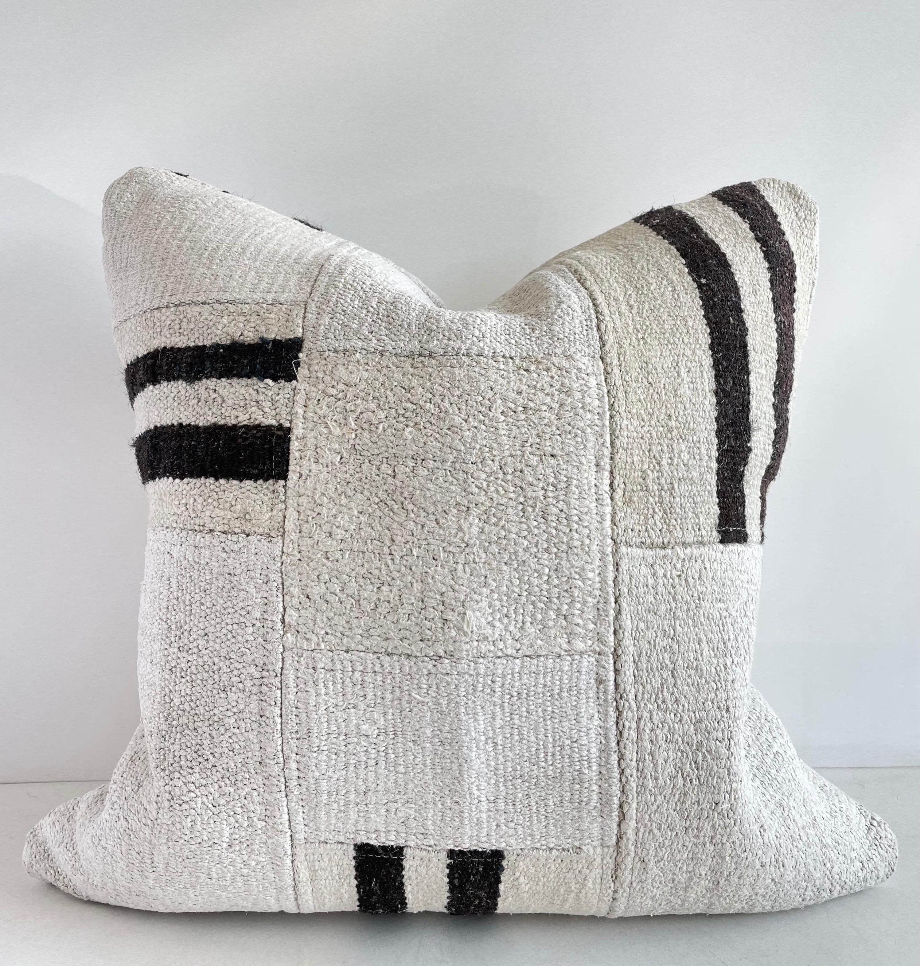 Creamy white hemp rug patchwork style pillow. Unique patchwork pillow has been made with parts of different Turkish rugs, in multiple white tones and stripes in brown. Double sided rug pillow has patchwork on both sides, and hidden zipper closure.