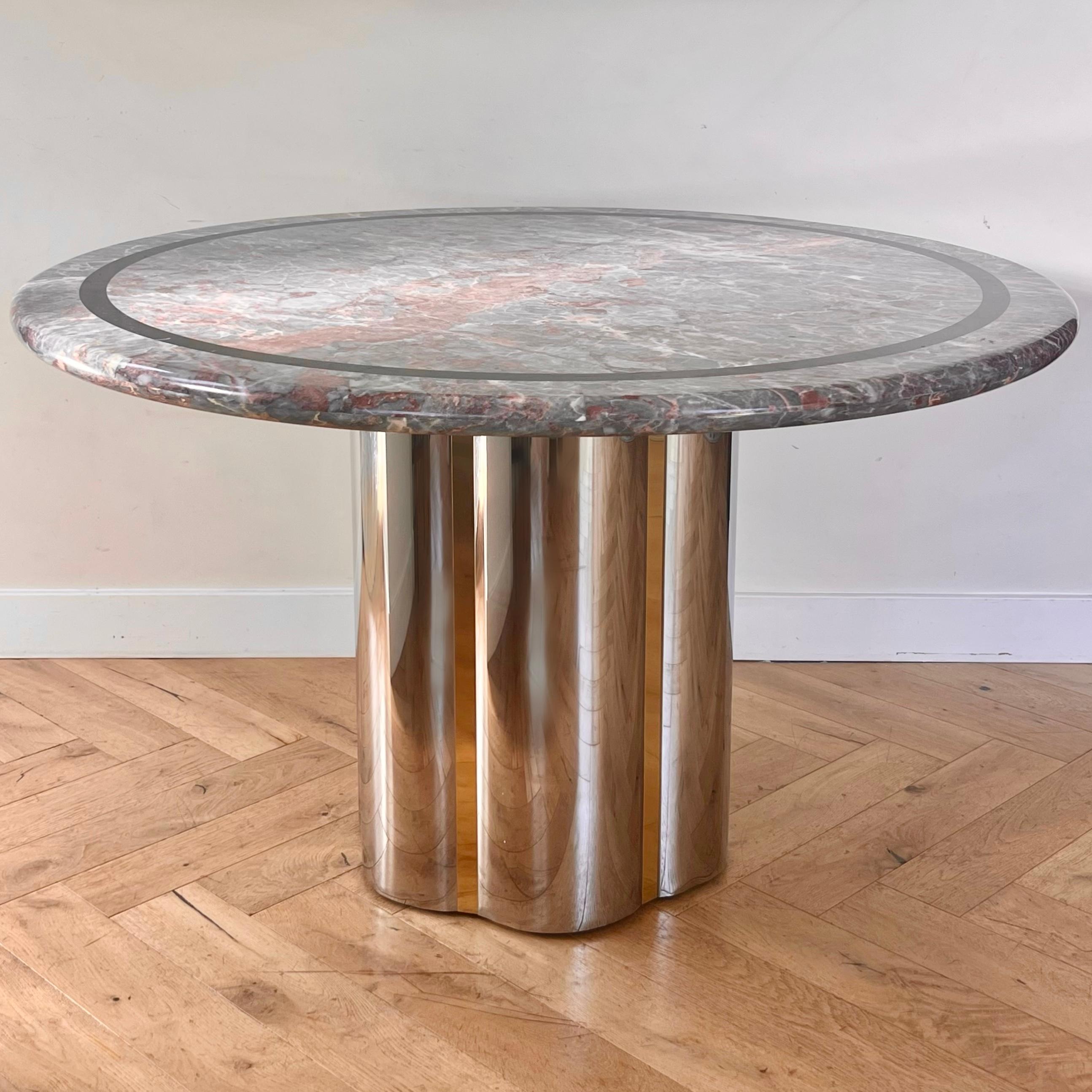 A pink and gray marble and metal dining table attributed to Karl Springer, late 20th century. The round top is vintage Italian marble in tones of peony, flesh, and ash, and features a black ring around the rim. The base is petaled sheets of steel