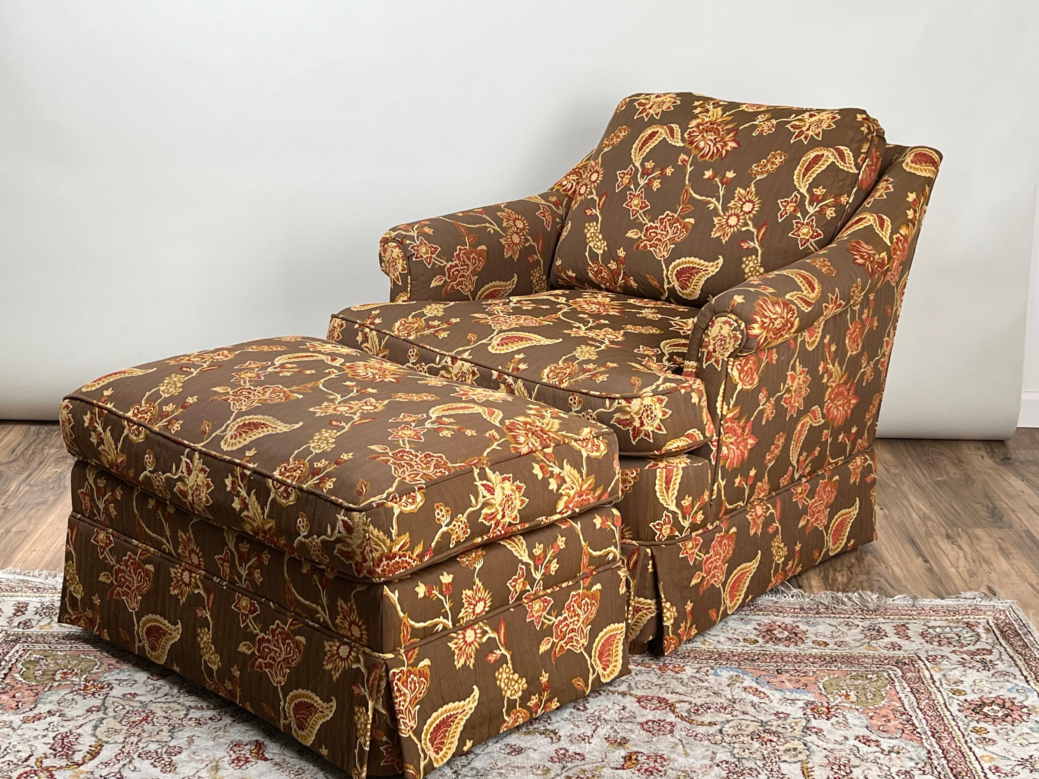 Questa invitante poltrona club vintage e il pouf abbinato uniscono comfort e stile in un design senza tempo. Rivestito su misura in un tessuto con una ricca fantasia nei toni caldi del marrone, dell'oro e del rosso con motivi floreali e paisley, il