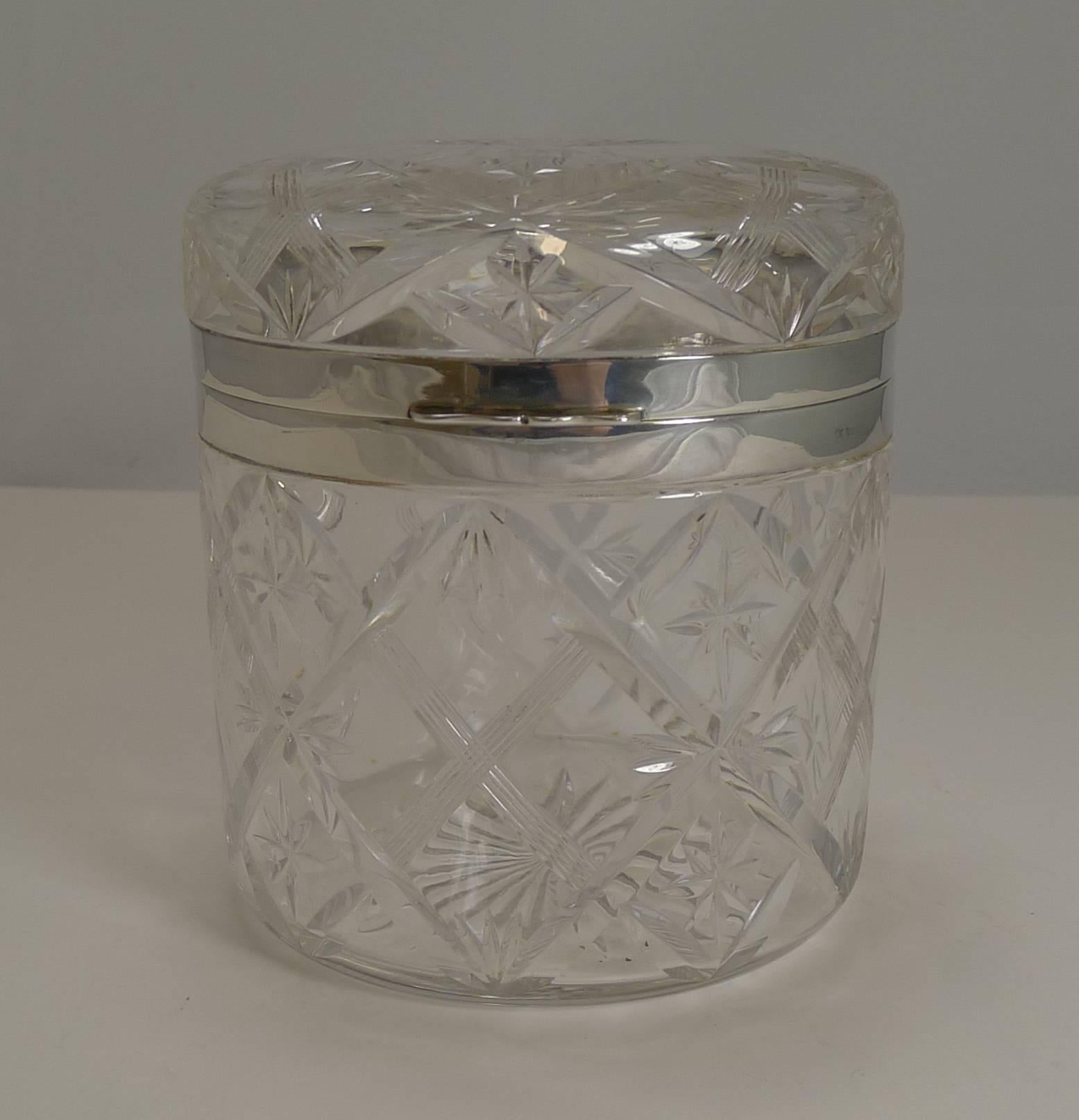 A magnificent large box made from a hefty piece of English crystal with a variety of intricate cutting creating an impressive and truly glamorous piece.

The hinged rims are made from English sterling silver with a full hallmark for the top-notch
