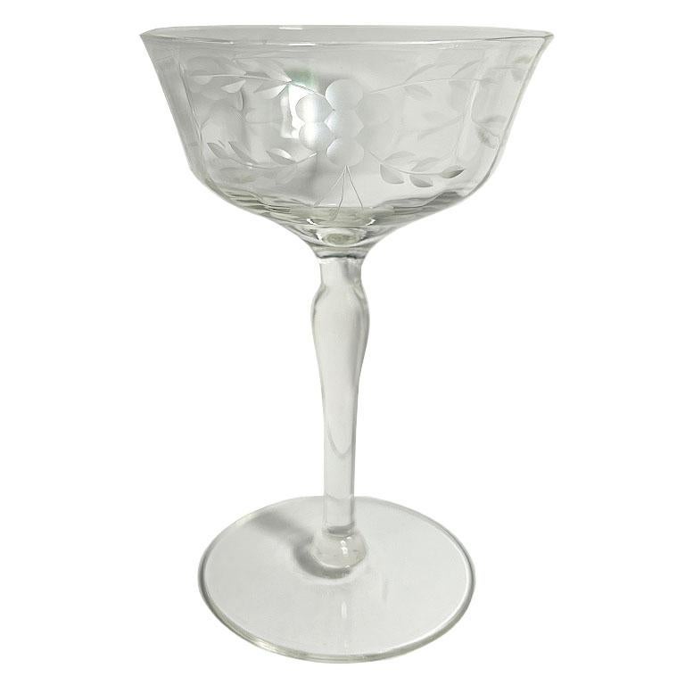A set of two optic cut flower motif champagne coupe glasses. This beautiful set is thought to be by Weston, and from the 1930's. They have a wide rim with a vertical optic cut around the body. The stems are tall and in an hourglass shape. Around the