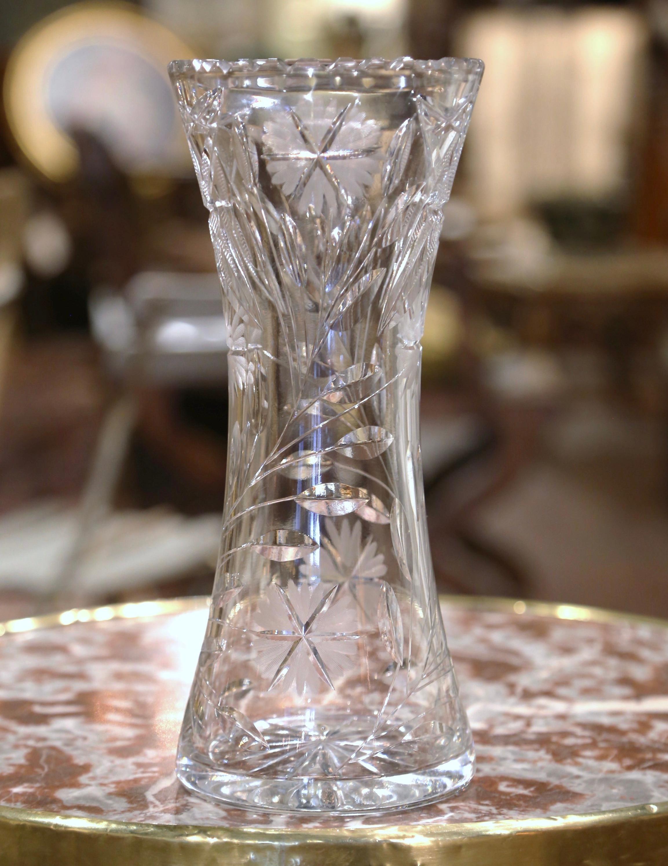 Decorate a console or buffet with this elegant crystal vase. Crafted in France, circa 1960 and round in shape with ridged rim, the large luxurious cut glass vessel is decorated throughout with flowers and leaves decor; the trumpet form vessel is