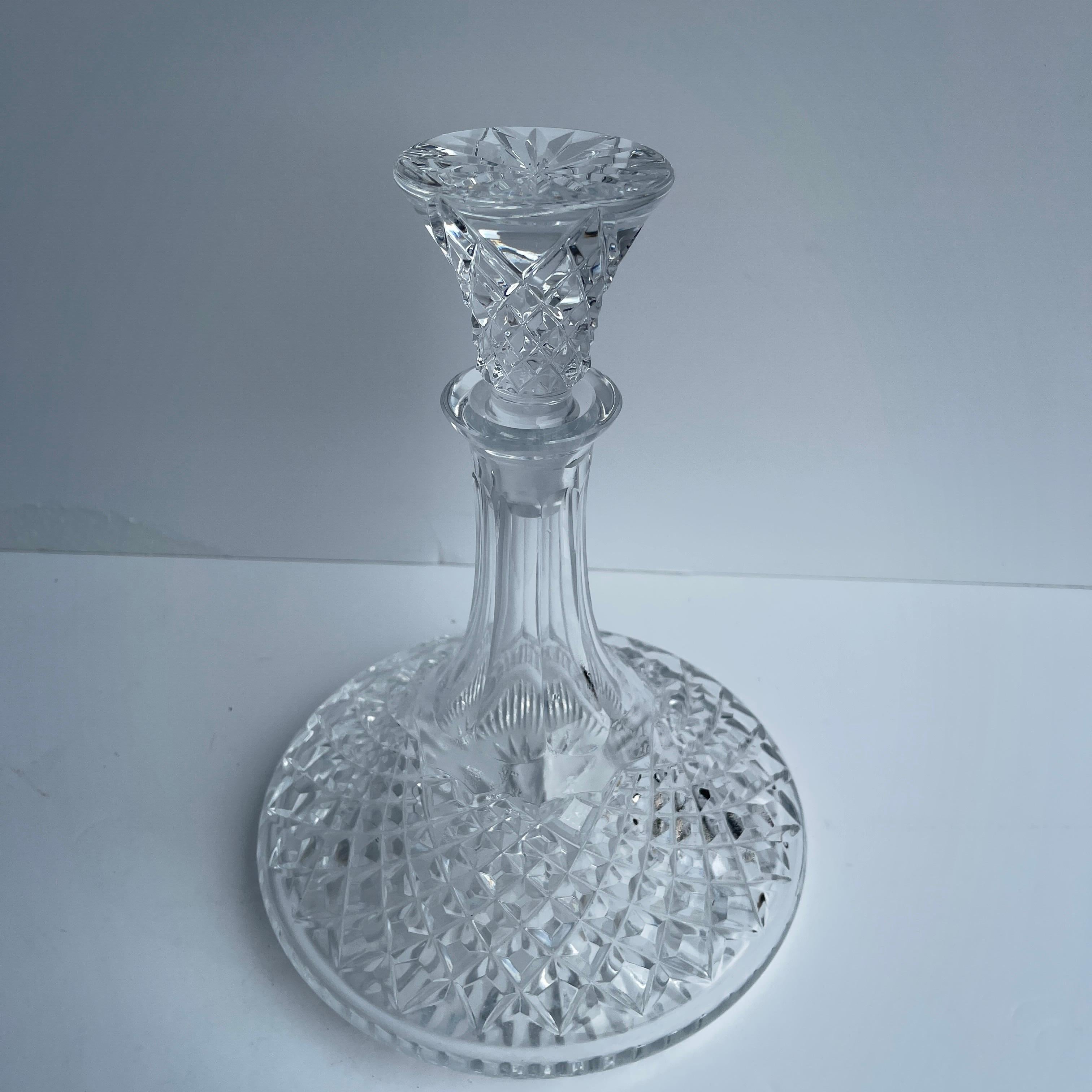 Early 1900's cut glass decanter.
This beautiful decanter is ornately carved throughout the generous base, long stem and flat top stopper. Tall and elegant, the decanter is perfect for wine or spirits. Holding your beverage of choice, the decanter