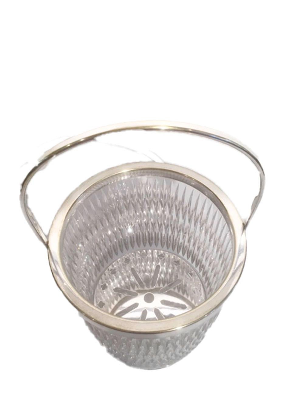 Mid 20th century heavy cut glass ice bucket of with silver plate rim and handle. The exterior is cut with three rows of closely spaced vertical lines creating an optical effect above a row of ovoid cuts at the base, the bottom is finished with a