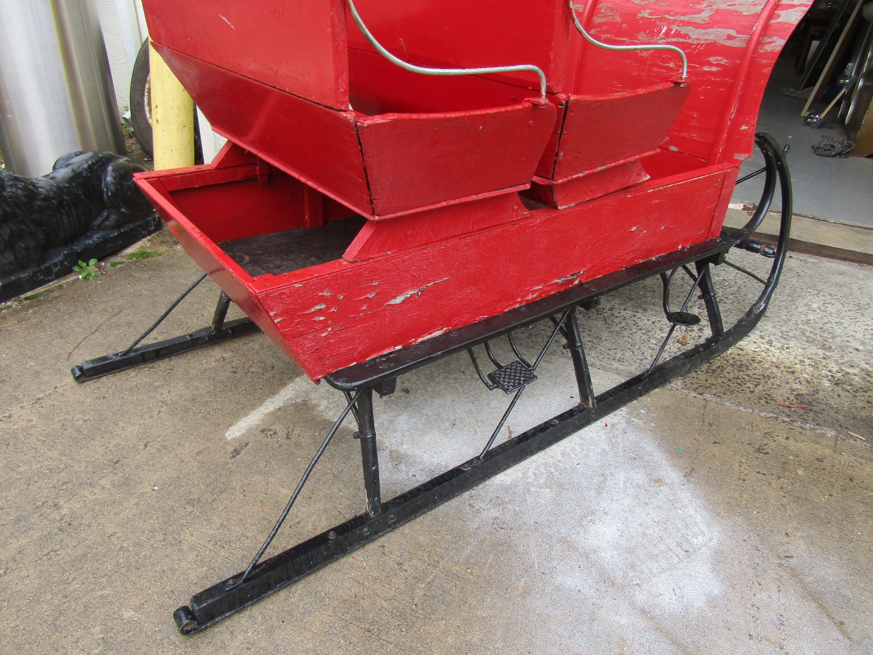 Beautiful antique cutter sleigh in red. This piece features a wooden top with 2 seats, all metal frame and vintage mojo perfect for any seasonal Christmas decor.