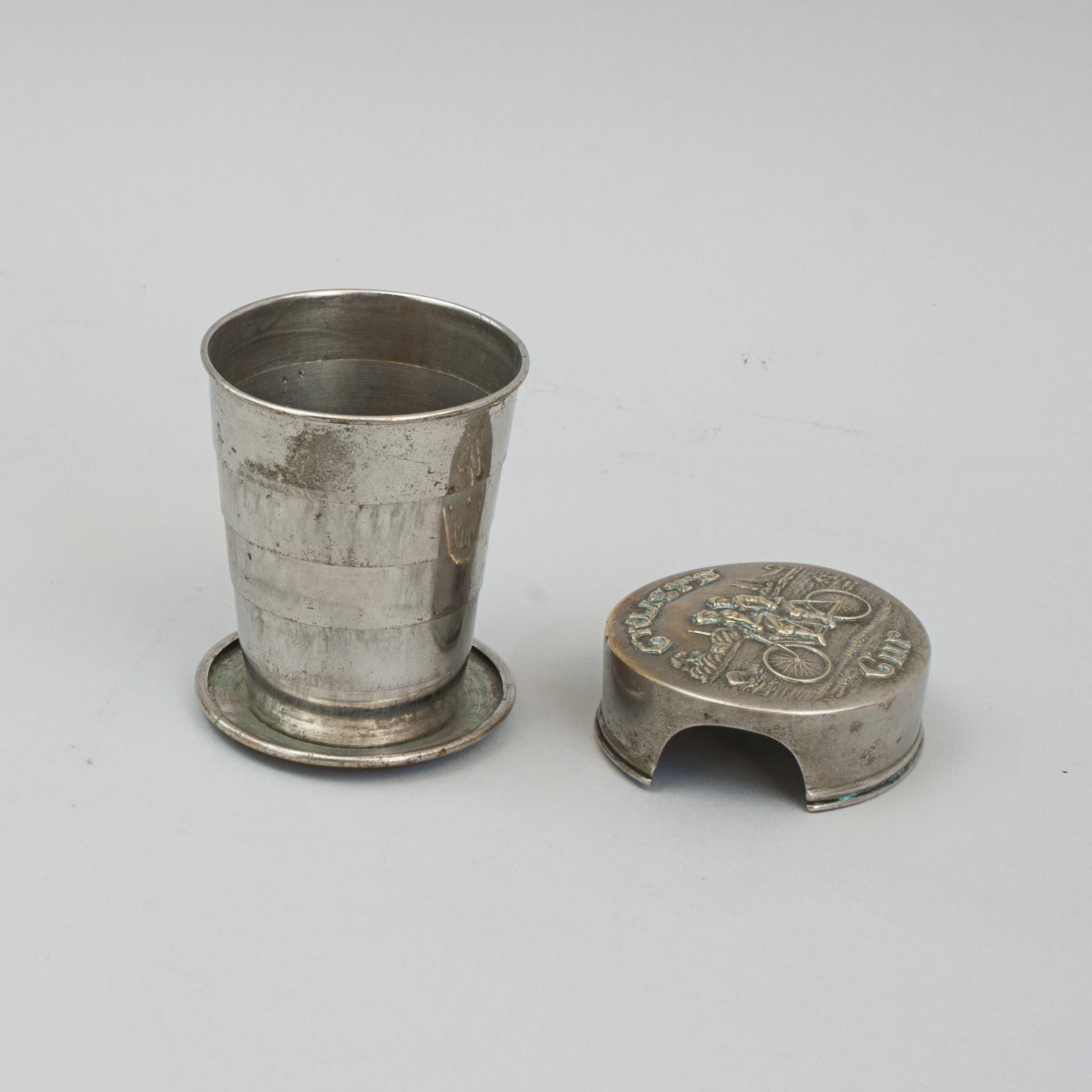 Antique Telescopic Cyclists Cup.
A cyclists telescopic cup made up of five graduating rings to form a relatively large cup with a turned over lip. The Victorian collapsible travel, bicycle cup has an embossed lid with a charming scene of two