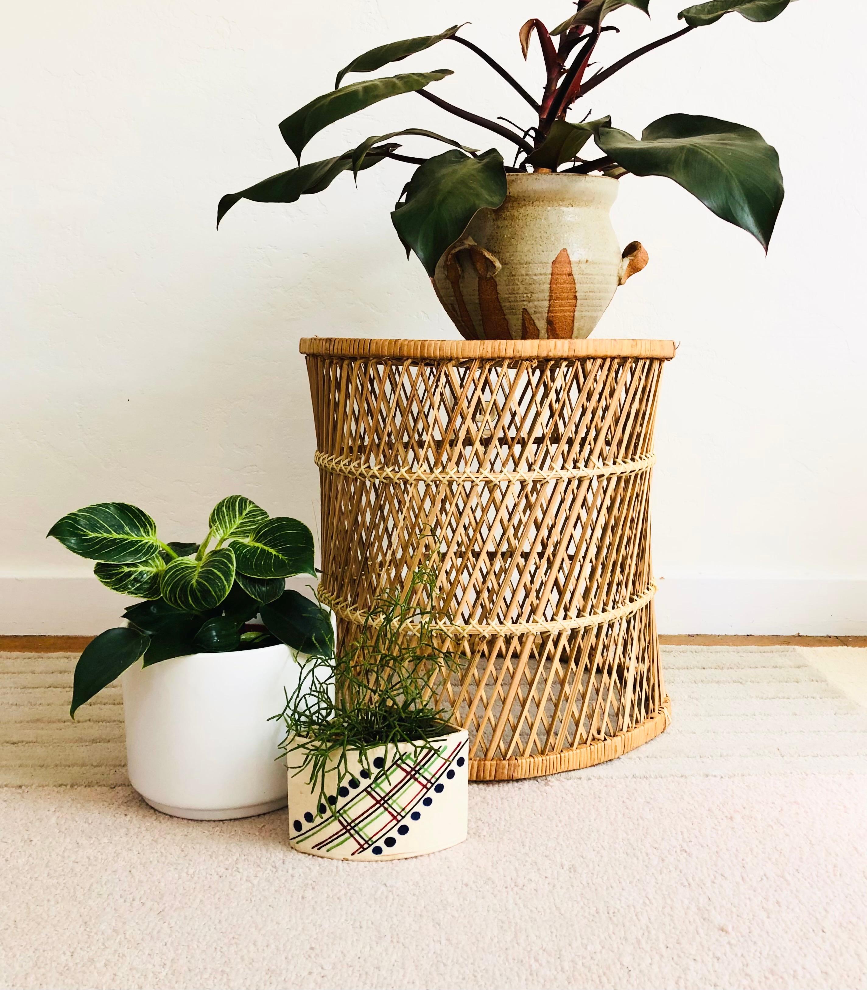 A vintage basket stool. Nice cylinder drum shape. Made of warm natural light brown pieces of wicker, woven into a diamond pattern on the sides and circular pattern on top. A versatile piece to use as a side table, plant stand, or as a storage basket