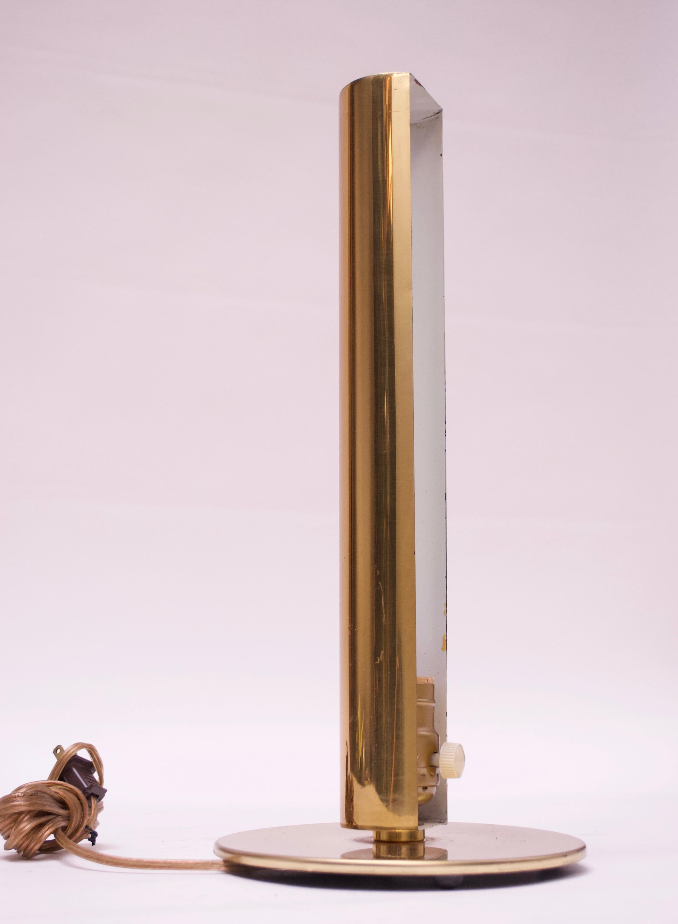 Lampe de table Kovacs en laiton composée d'un abat-jour cylindrique élancé avec un côté ouvert pour l'ampoule sur une base circulaire, vers les années 1960. Usure conforme à l'âge (à savoir éraflures et rayures, comme illustré, particulièrement