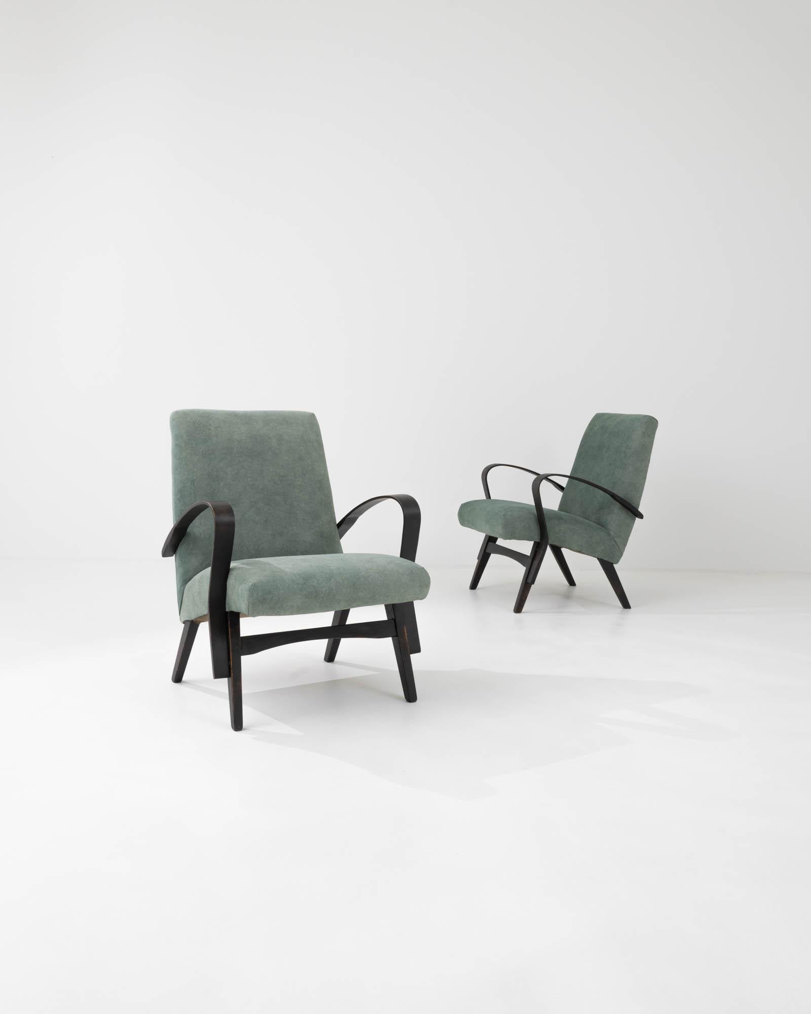 A pair of upholstered armchairs by Czech furniture manufacturer Tatra. Characterized by the clean lines that define their minimalist silhouette, these armchairs were crafted by the iconic Czech brand Tatra, and attributed to designer František Jirák