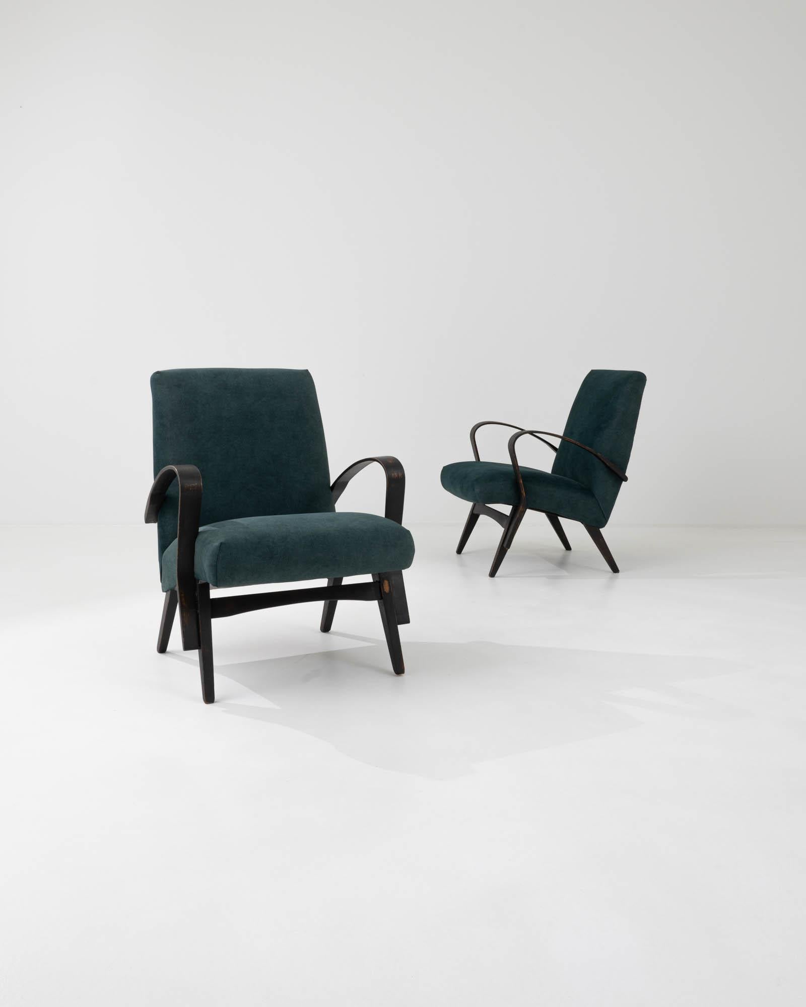 A pair of upholstered armchairs by Czech furniture manufacturer Tatra. Characterized by the clean lines that define their minimalist silhouette, these armchairs were crafted by the iconic Czech brand Tatra, and attributed to designer František Jirák