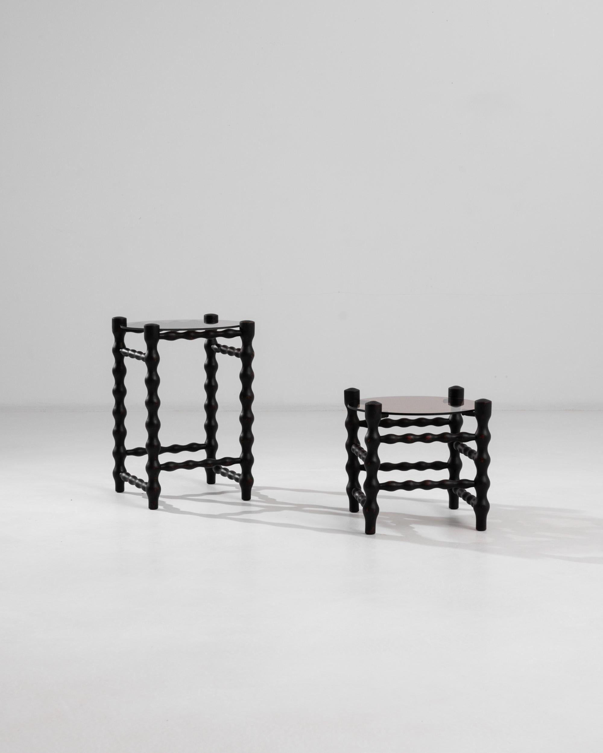 These vintage Czech side tables translate barley twist aesthetics into a modern language. The smoothed outlines of the spiral legs and side stretchers endow these pieces with an avant garde quality. The black finish elegantly dialogues with the