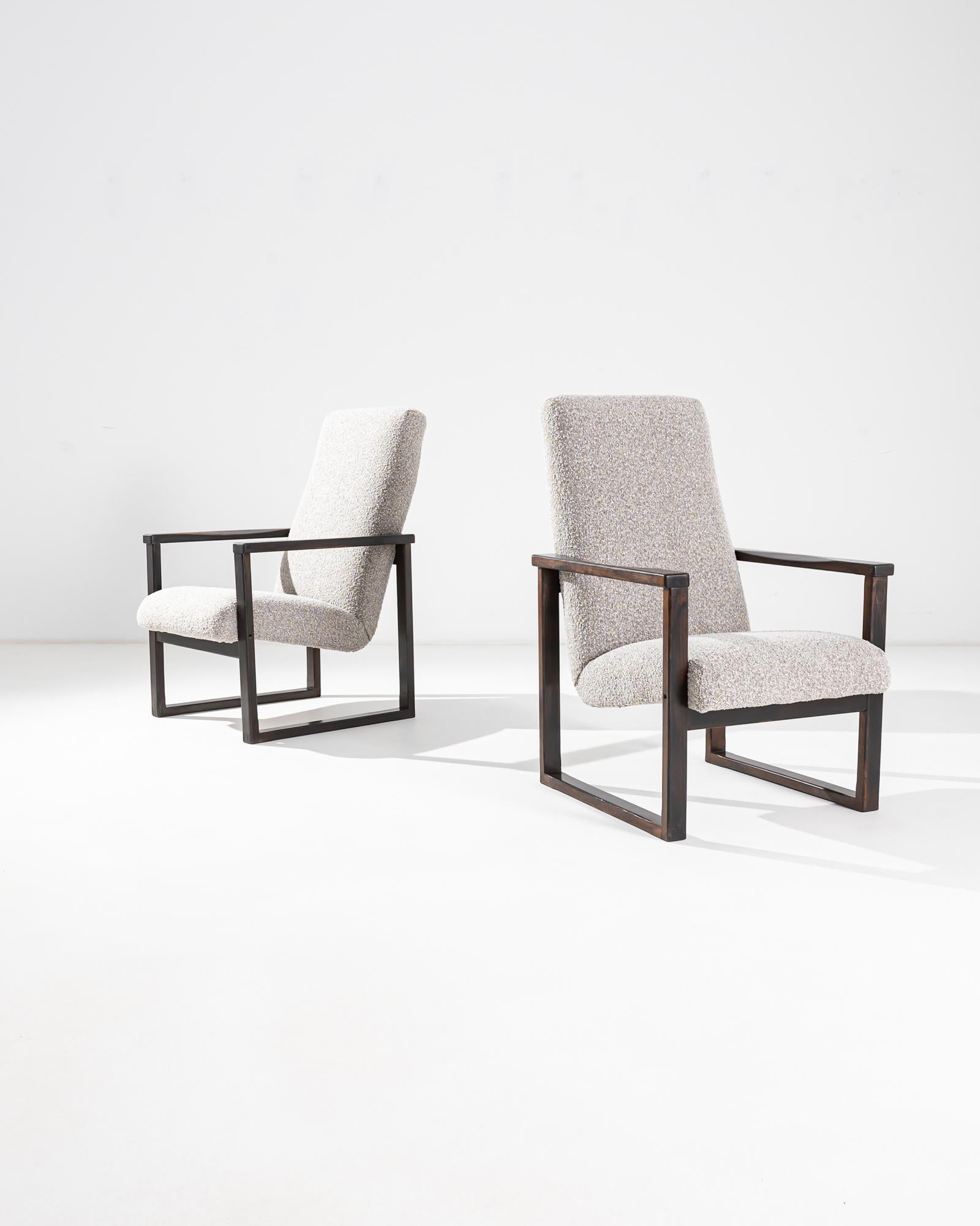 La silhouette graphique de cette paire de fauteuils modernistes vintage fait forte impression. Fabriqué en Tchécoslovaquie au XXe siècle, un siège rembourré semble flotter en apesanteur entre deux cadres parfaitement carrés en bois poli. Ce design