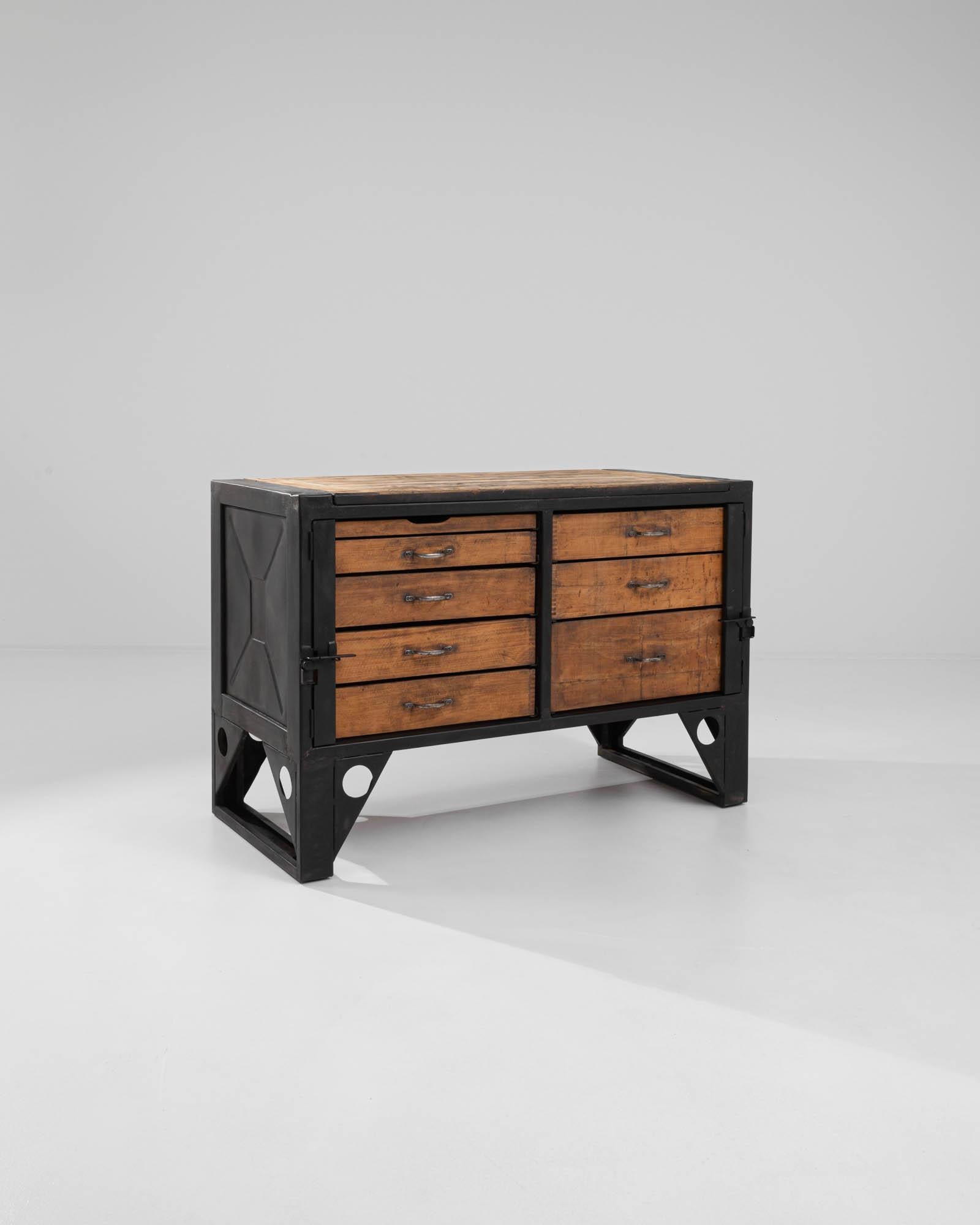 A sturdy metal base frames a bank of wooden drawer boxes. The distinctive patina made by the marks of time, reveals the history of this vintage chest. Made in Czechia in the 20th Century, this industrious set of drawers radiates a charming and tidy