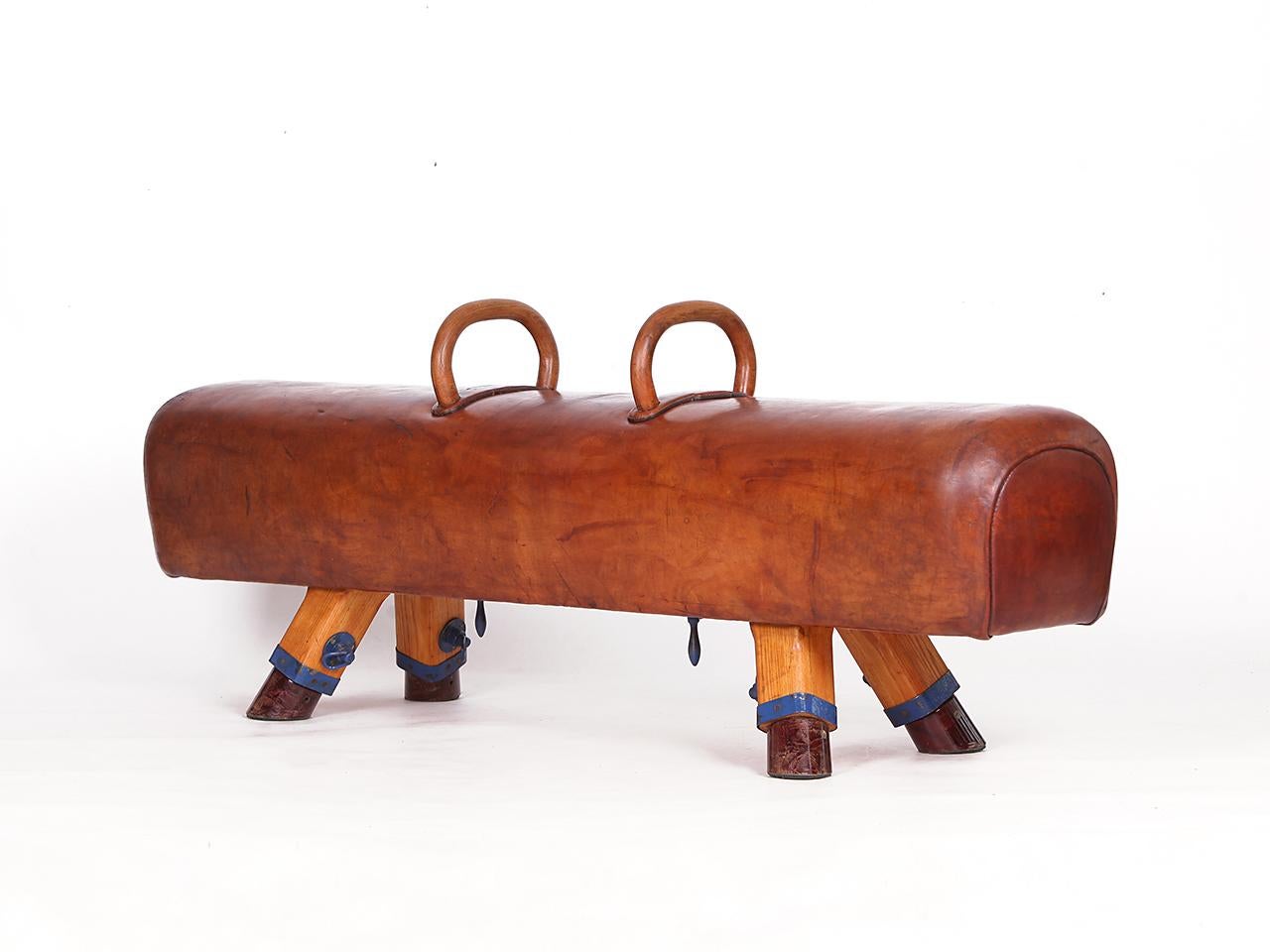 Pommel horse from former Czechoslovakia from the 1930s with beautiful patina, shortened to bench height 50cm and very good vintage condition. Completely restored. The iron feet are preserved. The thick leather has been cleaned and preserved. 
The
