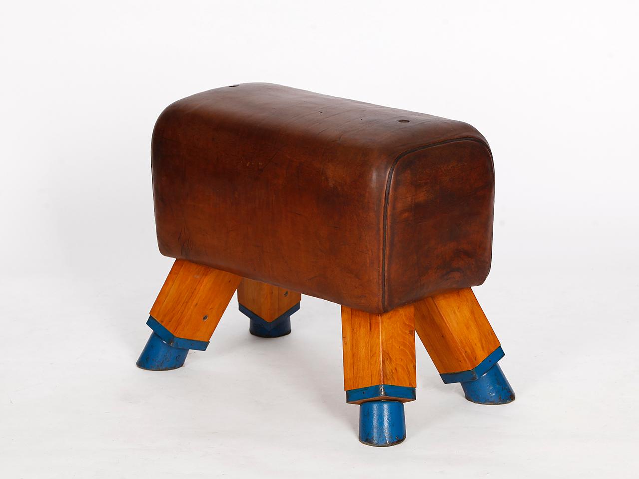 This Czech gym stool or turn bock was produced in the 1930s. It has been shortened to a height of 52 cm. The iron feet are preserved. The thick cowhide has been cleaned and preserved and has a very nice patina. All of our vintage gym equipment has