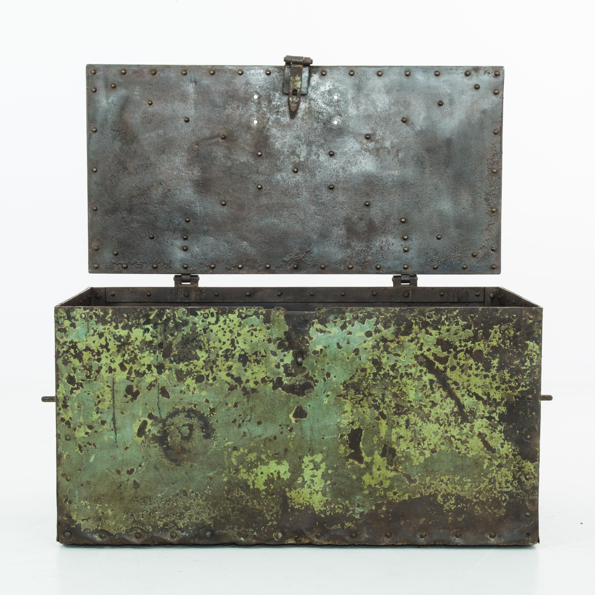 A metal trunk from Czechia, circa 1900, with an evocative patina. The original green paint has weathered to a distinctive timeworn texture, revealing the dark metal beneath. A color palette of lichen greens and slate gray soften the sturdy steel.