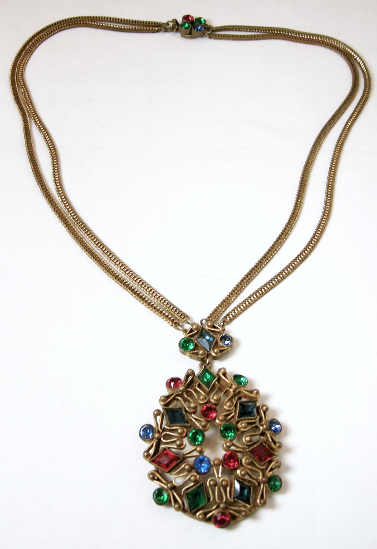 This vintage Czech festoon necklace has the 2 rows of gold tone chain leading down to the red, green and blue crystal drop.  It has a slide in clasp.  The necklace measures 19-1/2” long.  The drop is 2-3/4” x 1-3/4”.  This necklace is in excellent