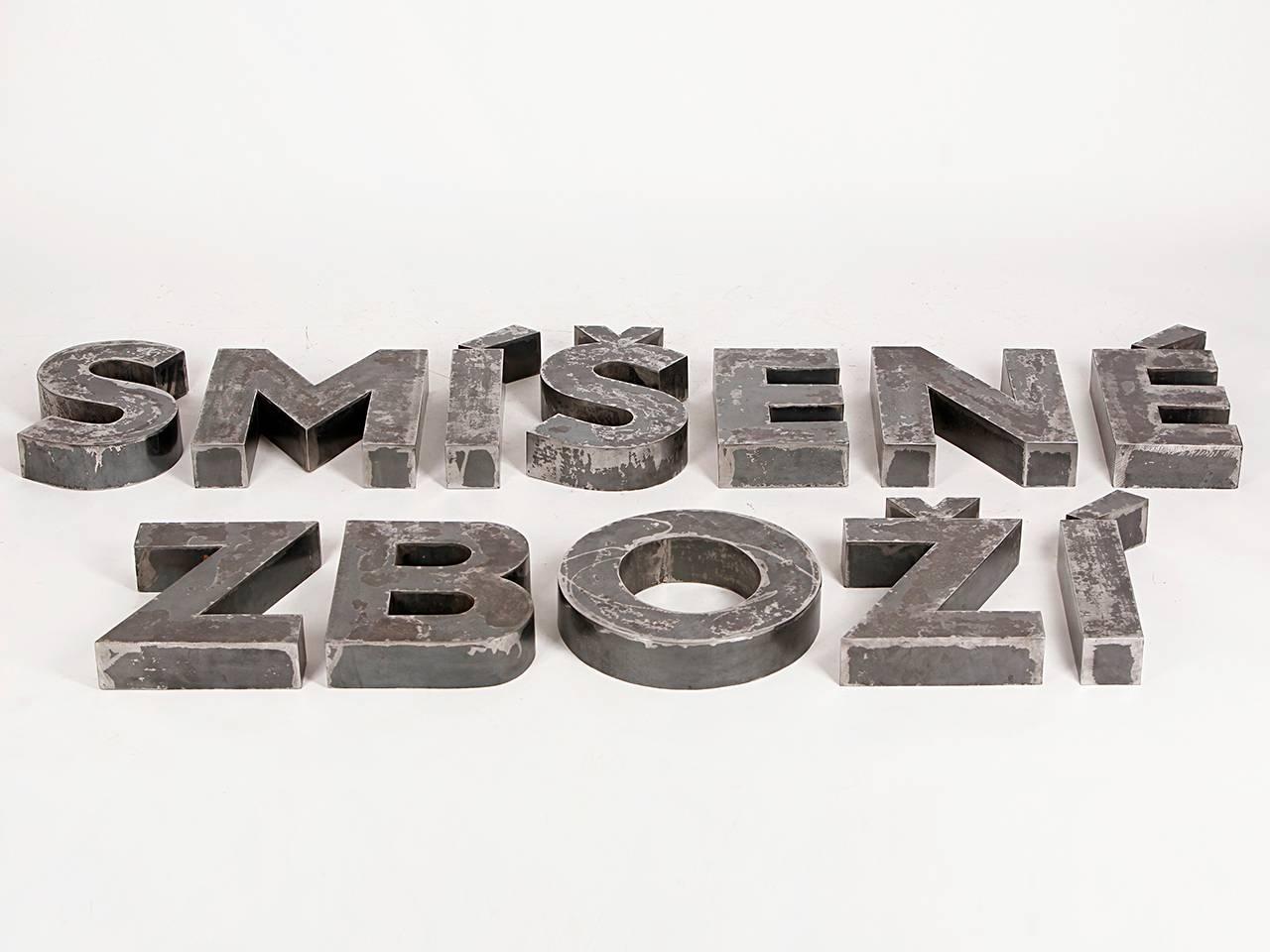 Dieser Satz von Ladenbuchstaben ist aus Stahlblech gefertigt und buchstabiert die tschechischen Worte 
