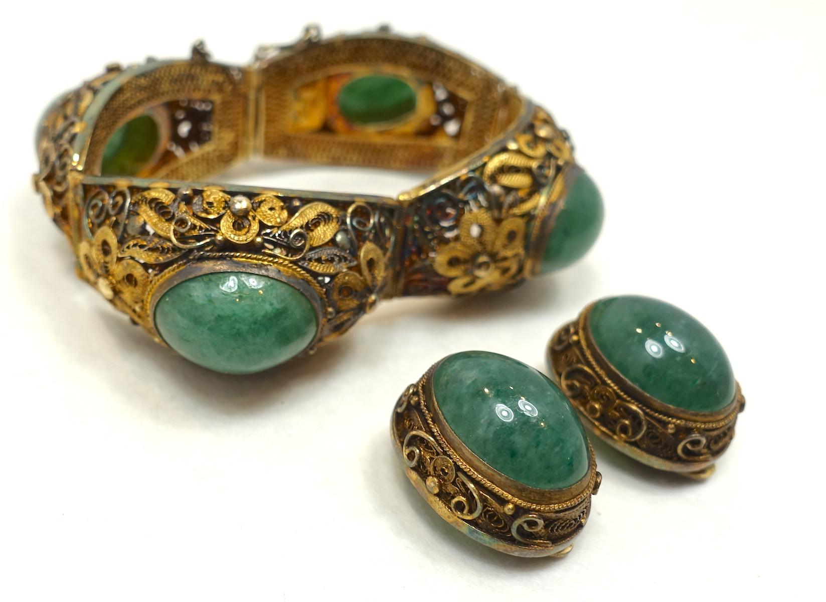 This vintage Czech bracelet and earrings set features large green cabochon-marbled stones in a textured sterling silver/gold wash setting. The bracelet measures 5-3/4” long x 7/8” wide with a safety chain and a slide in clasp. The matching clip
