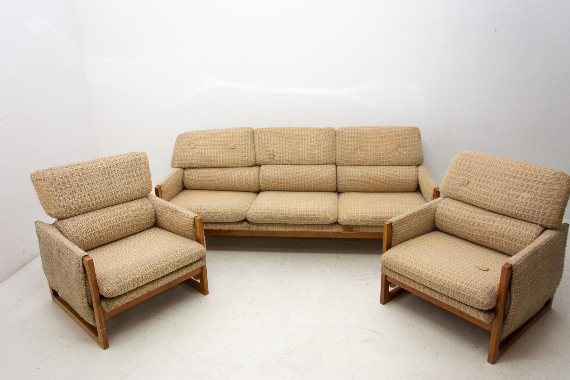 This lounge seating group was made in the 1980s in the former Czechoslovakia. Consists of one sofa and two armchairs. The set is upholstered in fabric. The structure is probably made of pine wood. The chairs are in good Vintage condition. The sofa