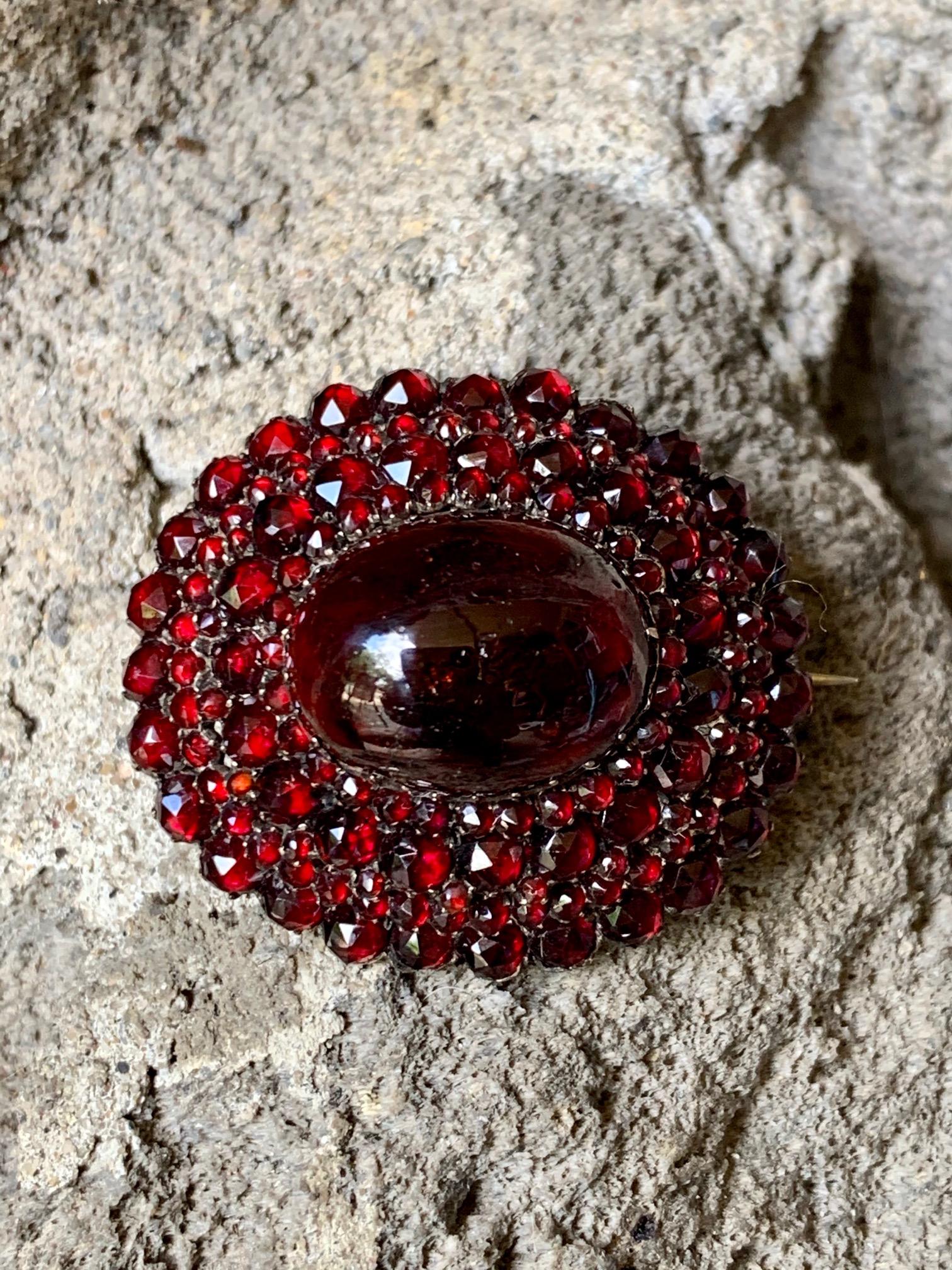 This beautiful oval, 20 x 15mm Garnet cabochon is surrounded by a multitude of faceted Garnets.  The brooch measures 40 x 35mm.

Weight:  14 grams