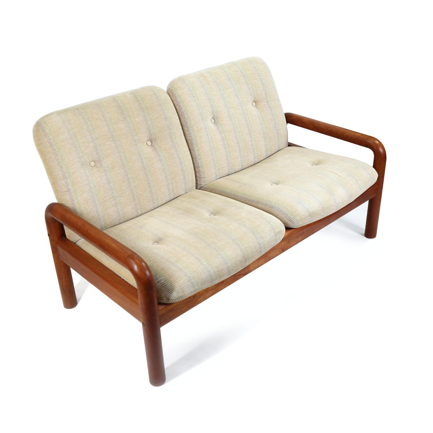 Vintage Danish modern loveseat size sofa by D-Scan. The solid teak wood frame supports the light beige upholstered cushions. Quality is in the details with the choice of durable, attractive teak wood and plush fabric. The light beige fabric has a
