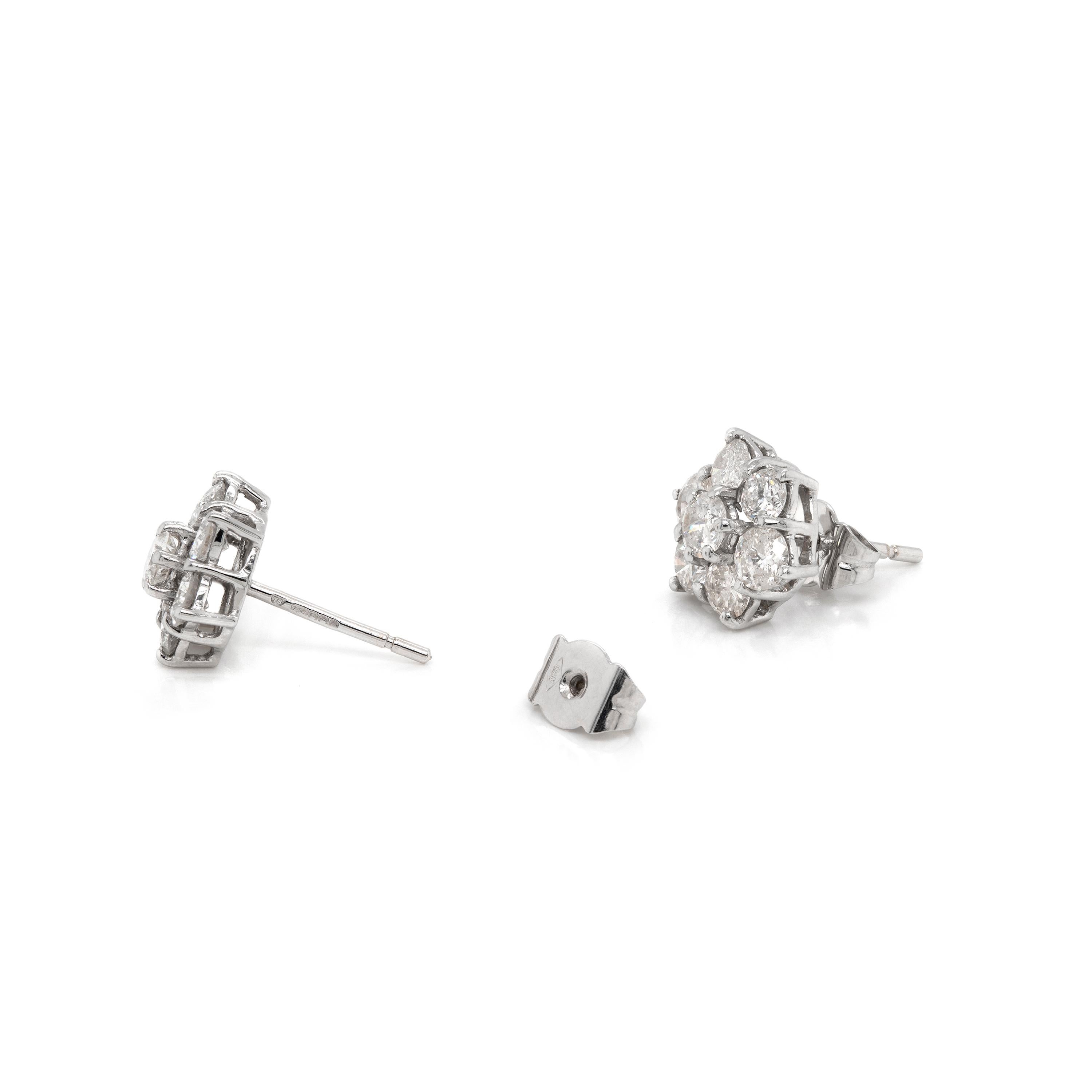 These exquisite vintage diamond cluster stud earrings feature seven round brilliant cut diamonds, with an approximated combined weight of 2.00ct, all mounted in 18 carat white gold, claw, open back settings. Hallmarked 750, stamped YS. England,