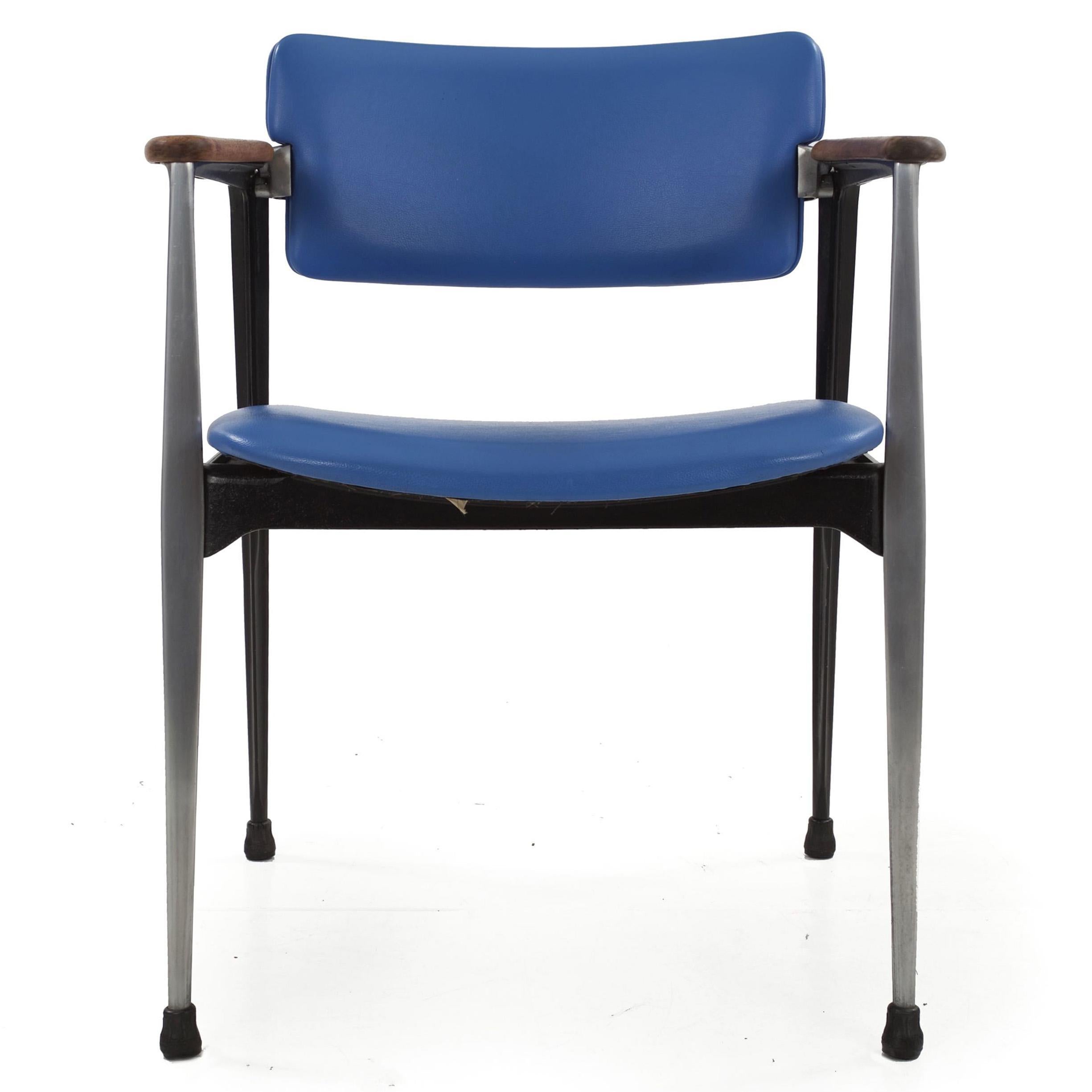 Built to last an eternity, this cast aluminum chair was designed by Dan Johnson for Shelby Williams and still retains the original manufacturer tag from Crucible Products. It retains the original light blue leatherette, which though worn still