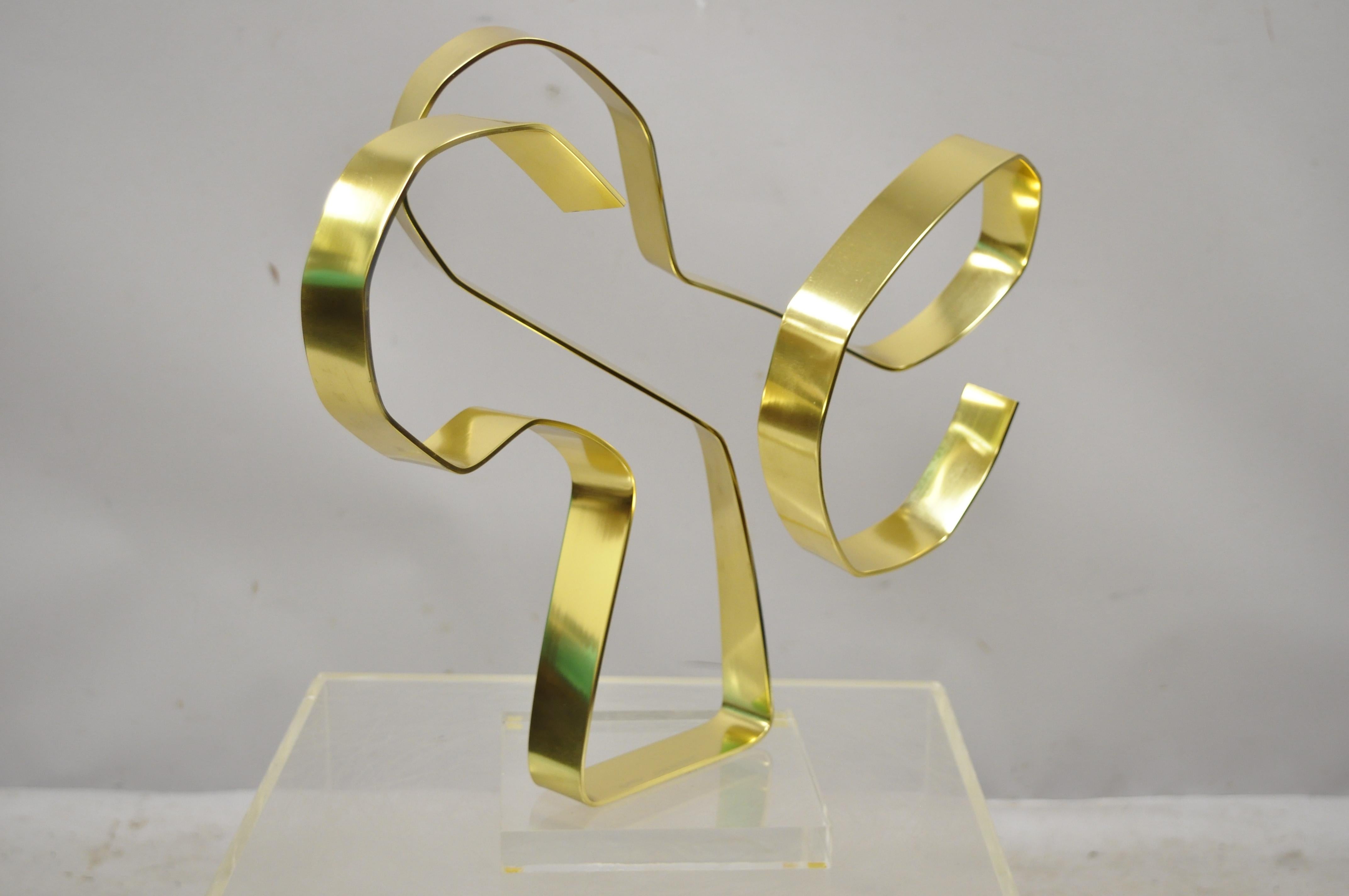 Vintage Dan Murphy 1976 brass ribbon abstract sculpture on Lucite base, signed. Item features Lucite base, original signature, sleek sculptural form, circa 1976. Measurements: 16