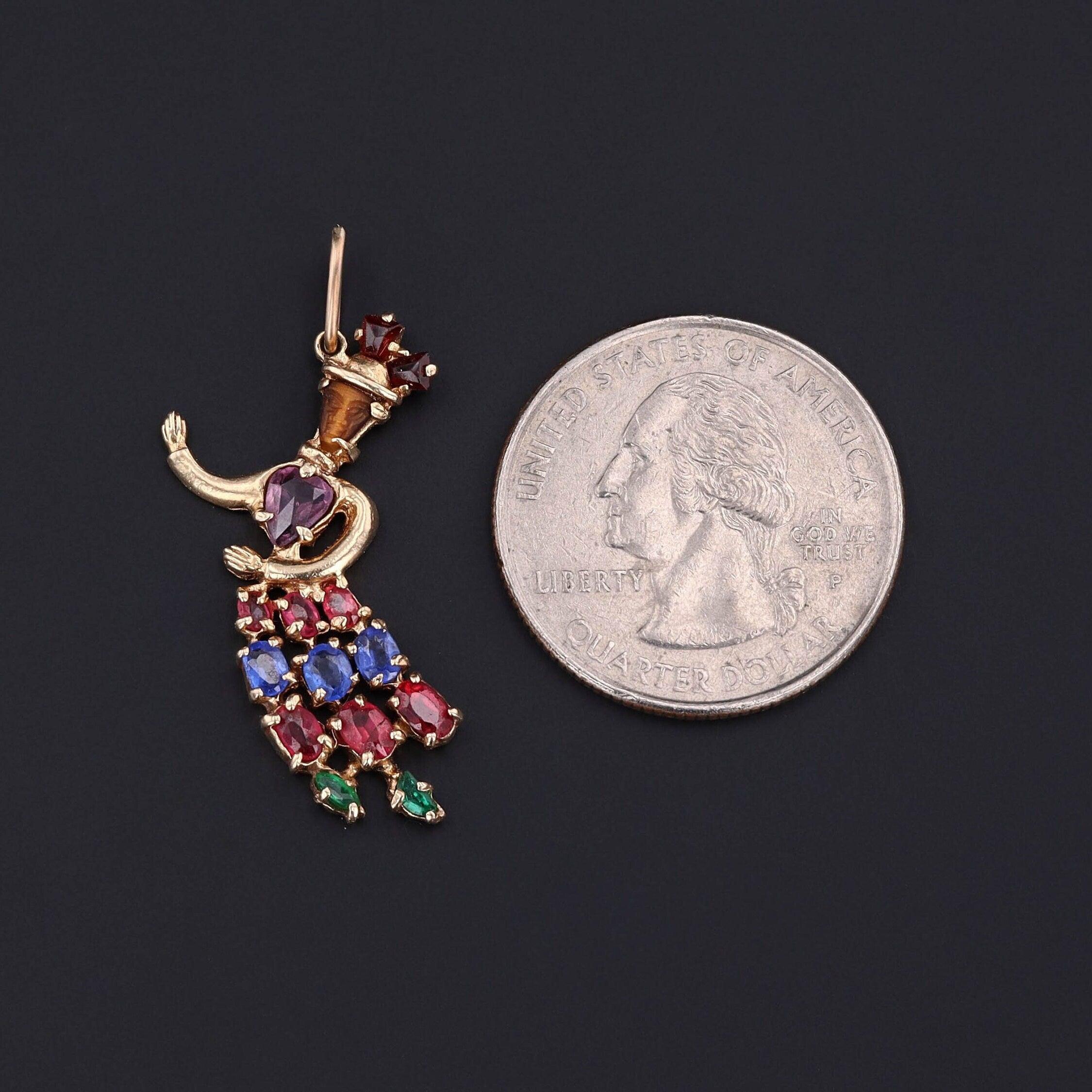 Ciondolo d'epoca a forma di donna danzante in oro 14k con occhio di tigre, ametista e doppiette di gemme, circa 1940-1955

Espressione gioiosa del design di metà secolo, questo ciondolo d'epoca (1940-1955 circa) cattura l'eleganza e il movimento di