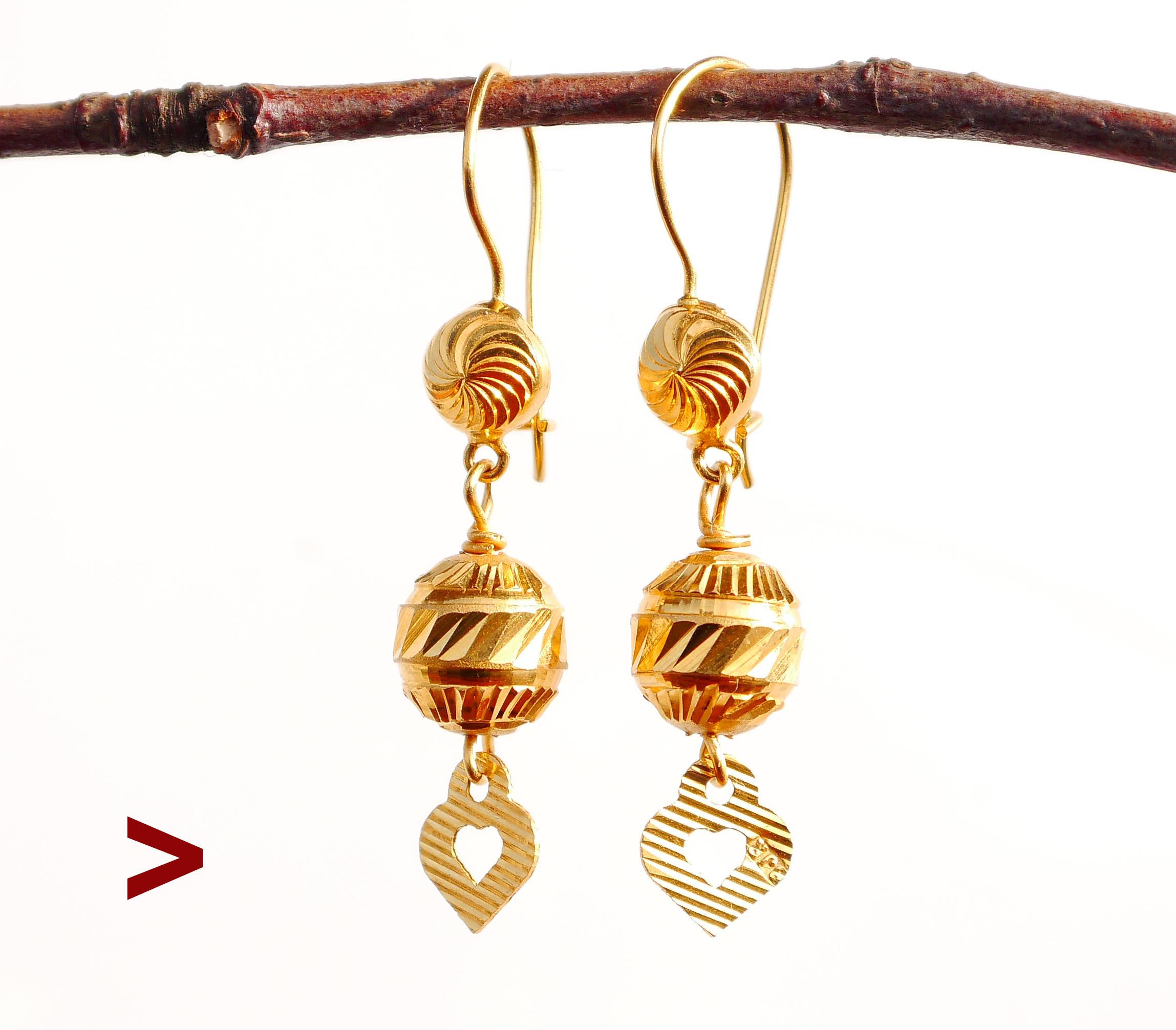 A pair of dangles with faceted parts in solid 21K Yellow Gold. Origin : likely Middle East.

Tested solid 21K Gold. Fine used condition, no dents or other damages, no repairs.

Each ring is 38 mm long including the hanger. Each ball Ø 7.5