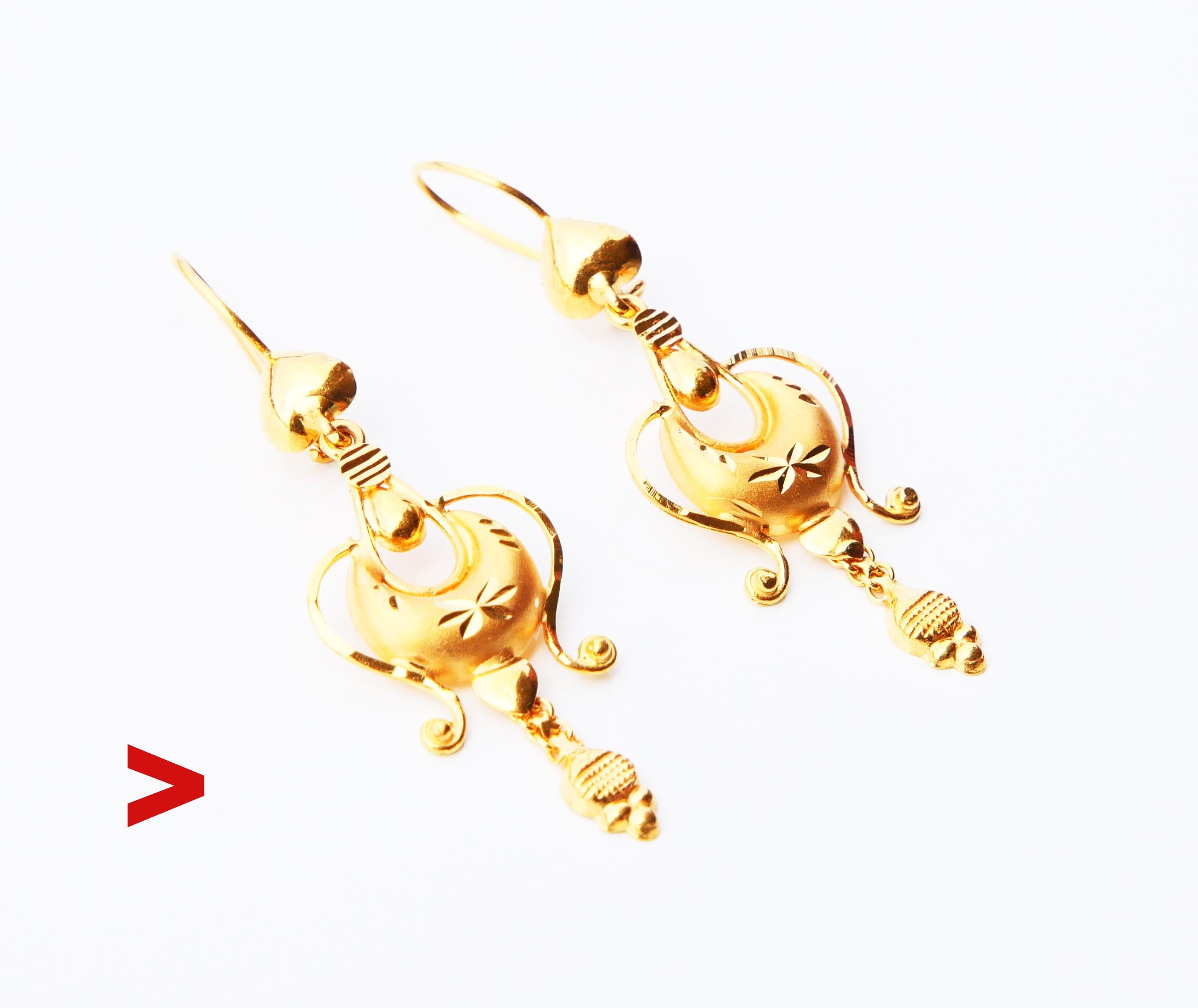A pair of fancy dangles on hooks with multiple joined parts: some of them have satin surfaces, some polished and faceted to play with light. Hallmarked 21K, maker and exact period of manufacture unknown. Metal tested solid 21K Gold.

Each earring is