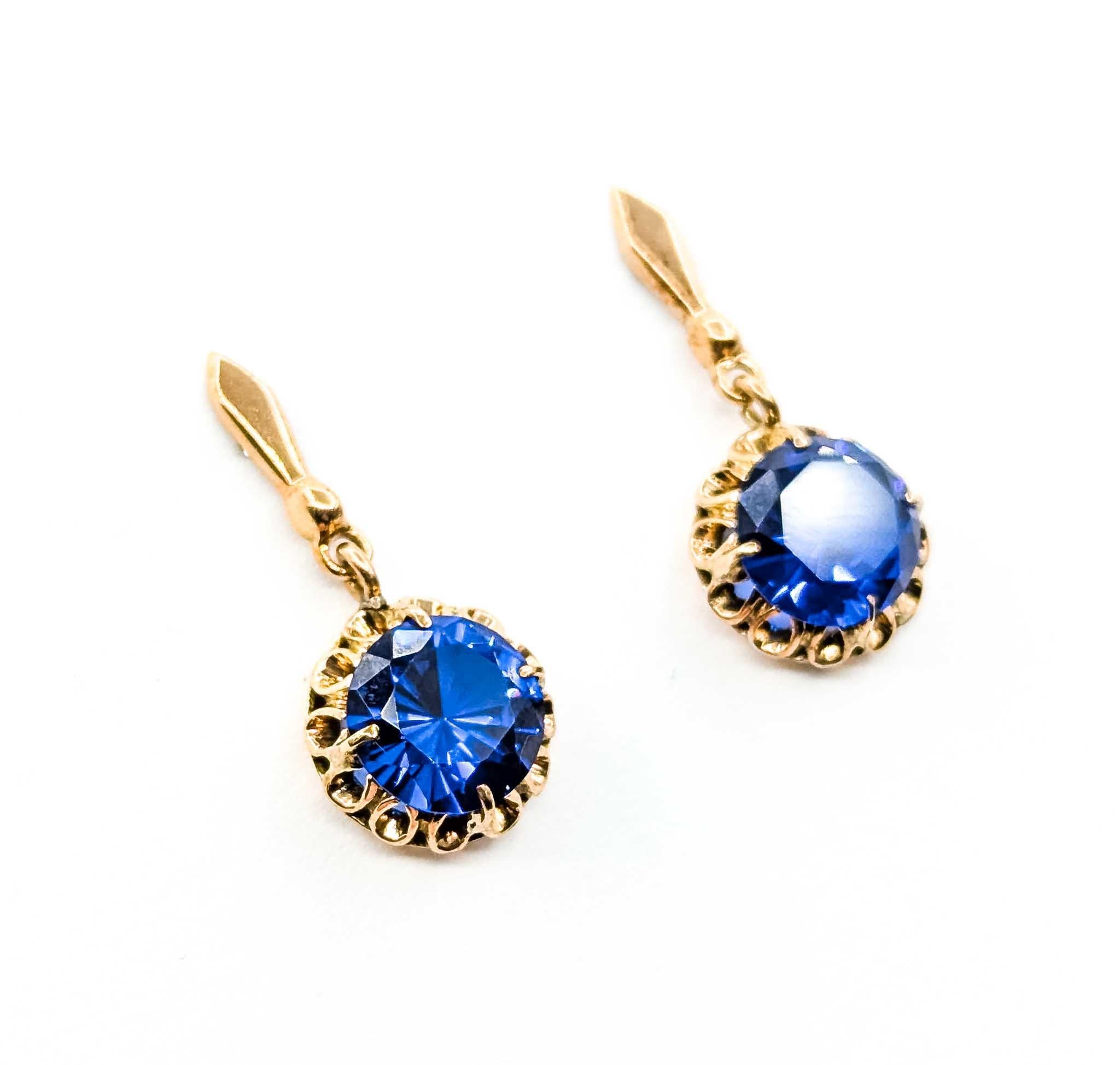 Introducing these exquisite Vintage Dangle Earrings, crafted in 14k yellow gold and featuring captivating 9.5mm synthetic sapphires. The design of these earrings is reminiscent of a bygone era, combining timeless elegance with a modern twist. The