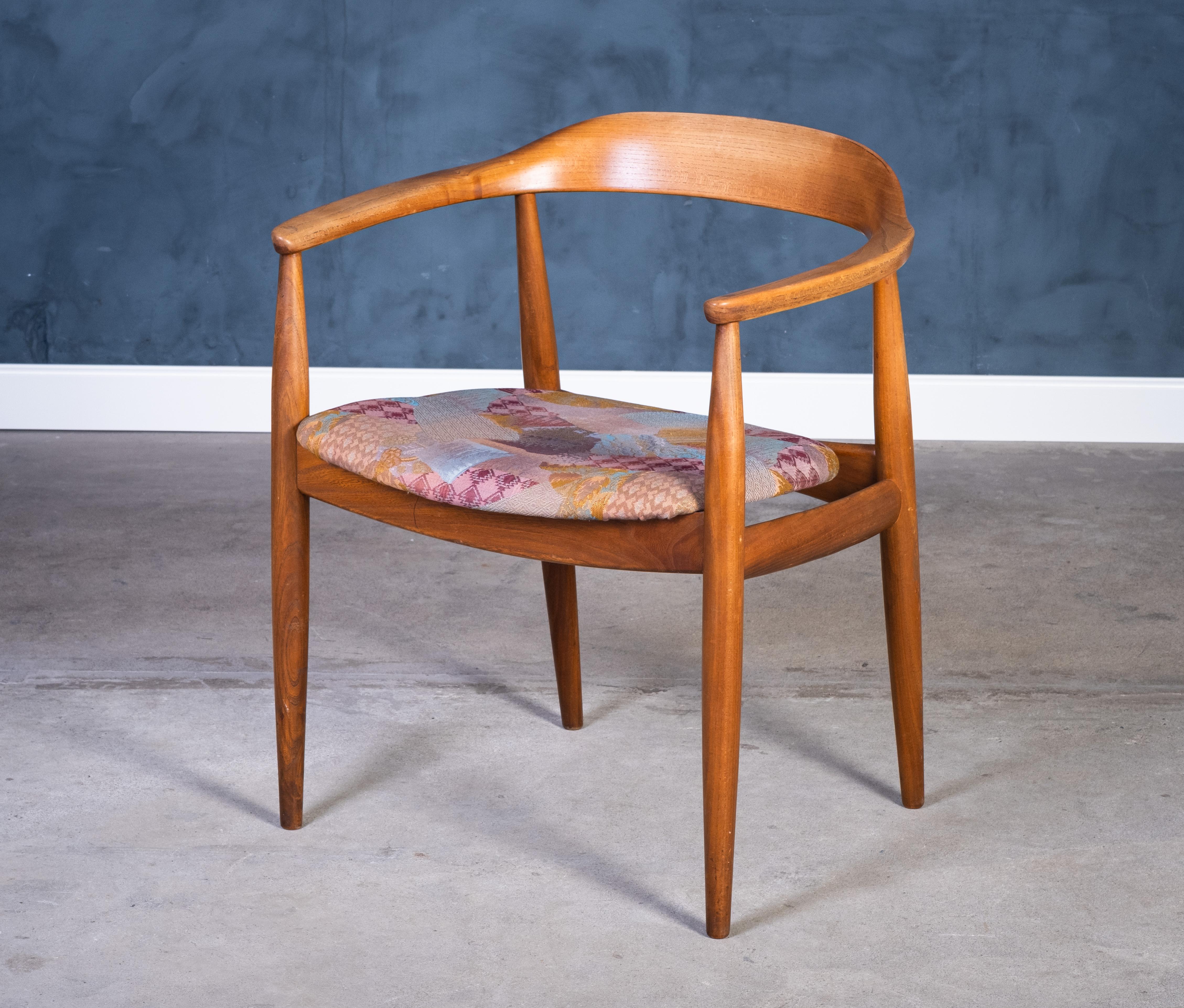 A classic vintage armchair designed by Illum Wikkelsø and crafted by renowned cabinetmaker Niels Eilersen in Denmark during the 1960s. Constructed from beautiful elm wood and featuring its original upholstery, this chair is a true example of Danish