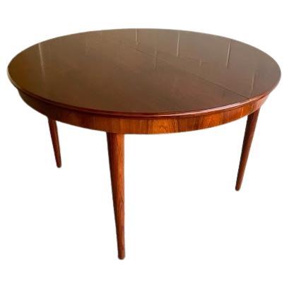 Dieser atemberaubende runde Esstisch von Bernhard Pedersen & Son ist ein Beispiel für die raffinierte Handwerkskunst des dänischen Mid-Century Modern Designs. Der Tisch ist aus reich getöntem tropischem Hartholz gefertigt und zeichnet sich durch ein