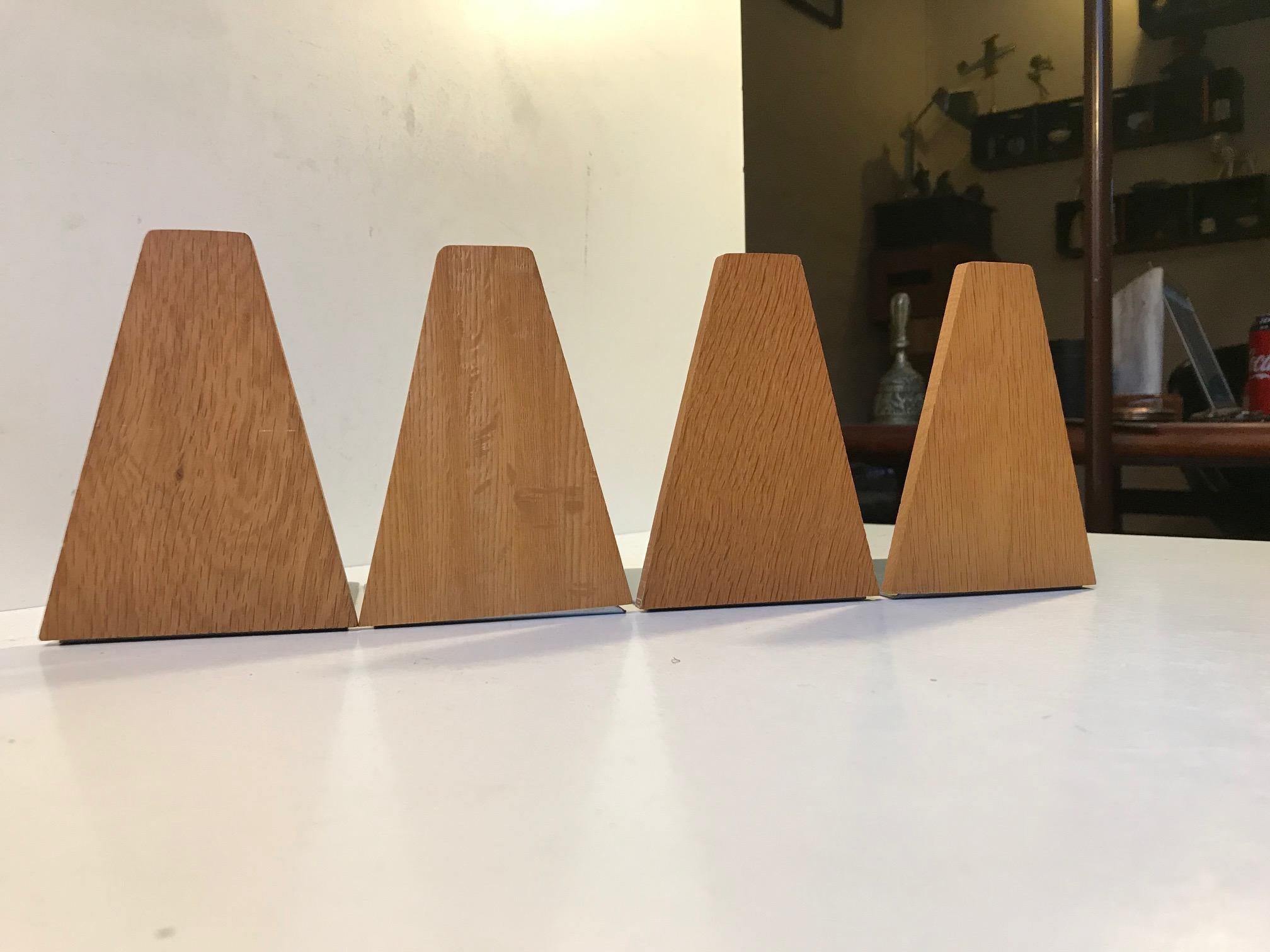 A set of four bookends in untreated oak with steel rests. Designed/manufactured by ESA in Denmark during the 1960s or 1970s in a style reminiscent of Kai Kristiansen.