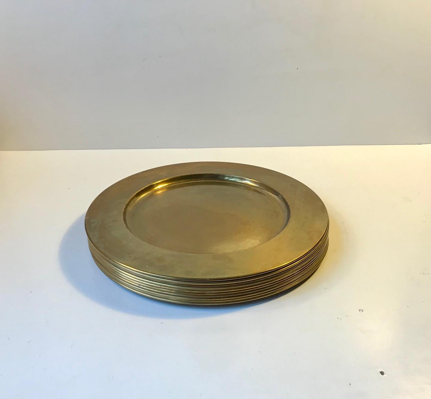 Set of 10 cover plates or dishes in solid brass. Manufactured by Stelton in Denmark during the 1960s in a style reminiscent of AJ Brass-ware. The plates are unpolished and 1 or 2 of them shows ware and patina here and there.