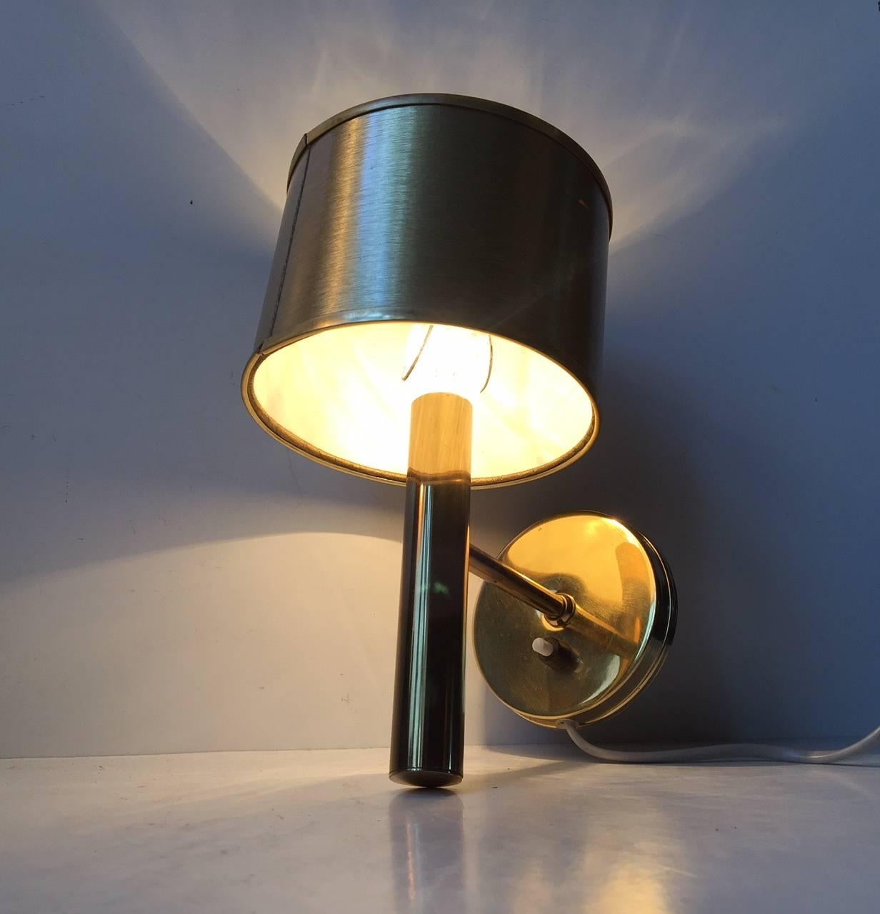 Fixed wall light designed and manufactured by Svend Mejlstrøm in Denmark during the 1960s. Its made from polished brass and has its gold-colored textile shade that came with it originally.