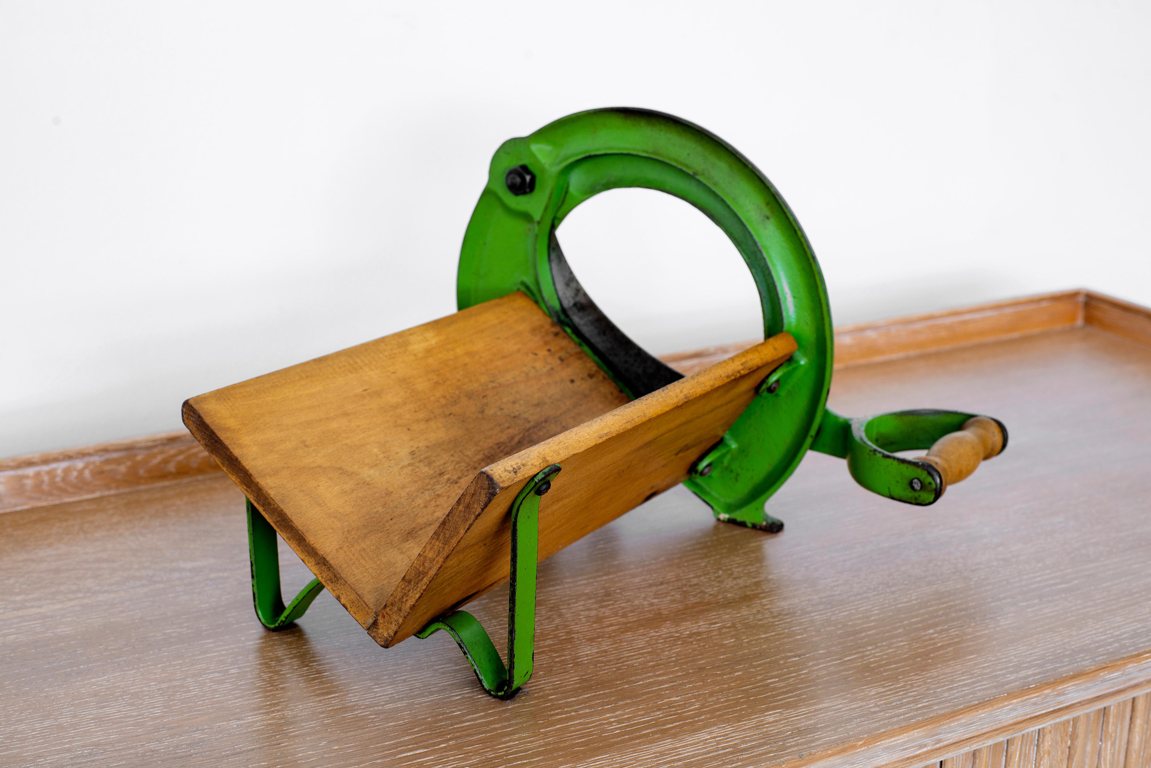 Vintage Danish bread slicer with original green paint and wood block for Raadvad. Faded golden letters and crowns read Raadvad. Original blade intact and could still be used to slice bread or be a unique decorative piece.