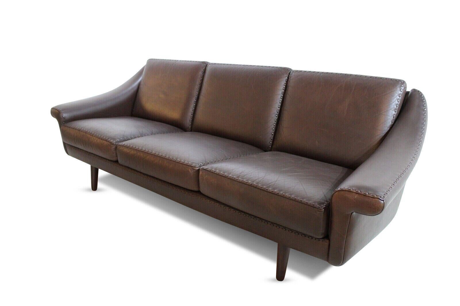 A 1970's Danish brown leather three seater sofa. 

Set on teak legs with attractive stitching detail.

This sofa is in excellent vintage condition with an original authentic patina to the leather.
 