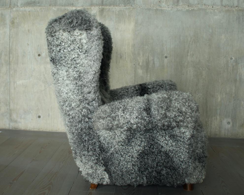 Vintage Danish cabinetmaker Lounge chair in Gotland Lambskin, um 1950. Großes Modell aus weichem, gelocktem Schafsleder mit Beinen aus gebeizter Buche. Hervorragender Zustand mit leichten Gebrauchs- und Abnutzungsspuren. 

Einer von zwei