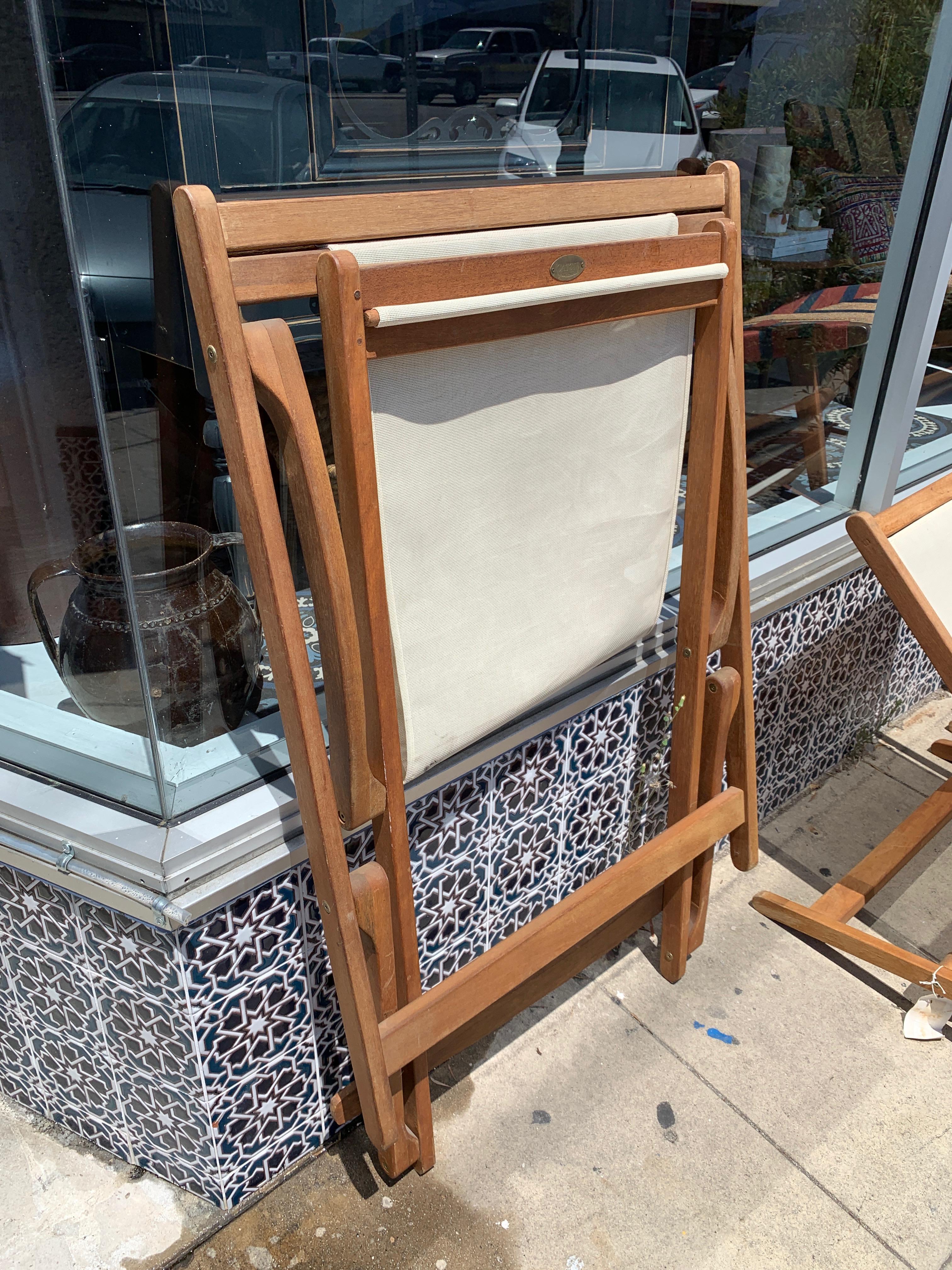 This set of three folding teak sling chairs are perfect as poolside sun loungers. The wooden frame, as well as folding, also gently rocks for deep relaxation in these low-profile, super-comfortable chairs. Vintage pieces in great condition made by