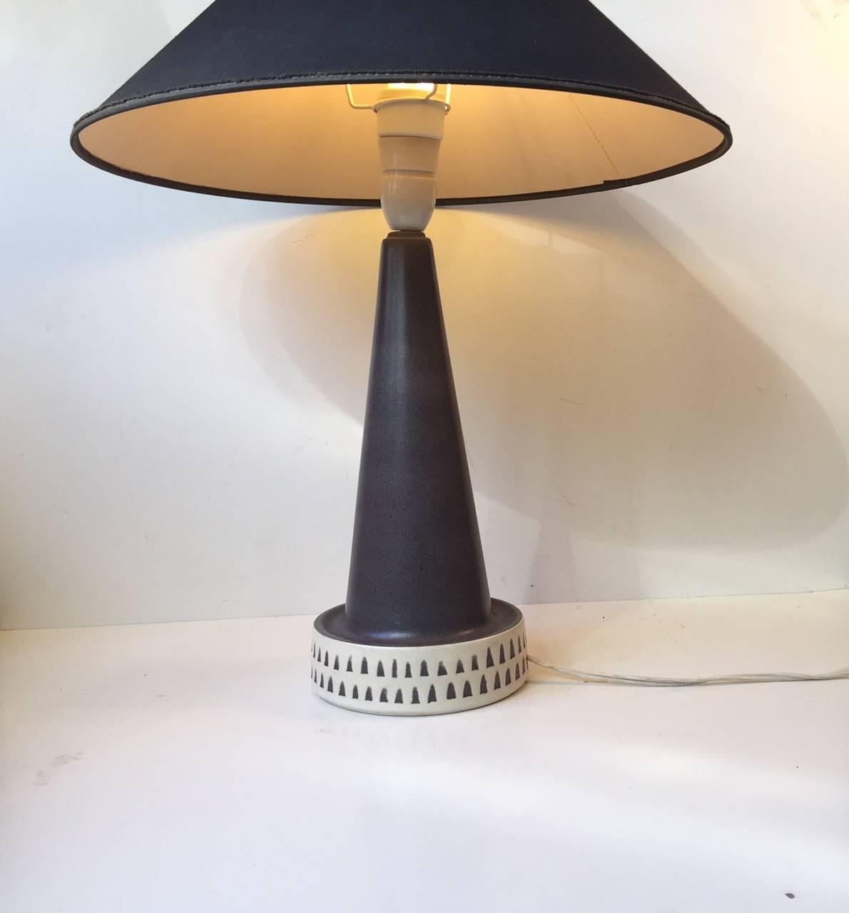 Rocket shaped pottery table light from the Danish lighting company Vitrika. This company only existed for a few years. The light features a slate grey main glaze and the creamy white base is decorated with a arrow pattern. Please personalize with