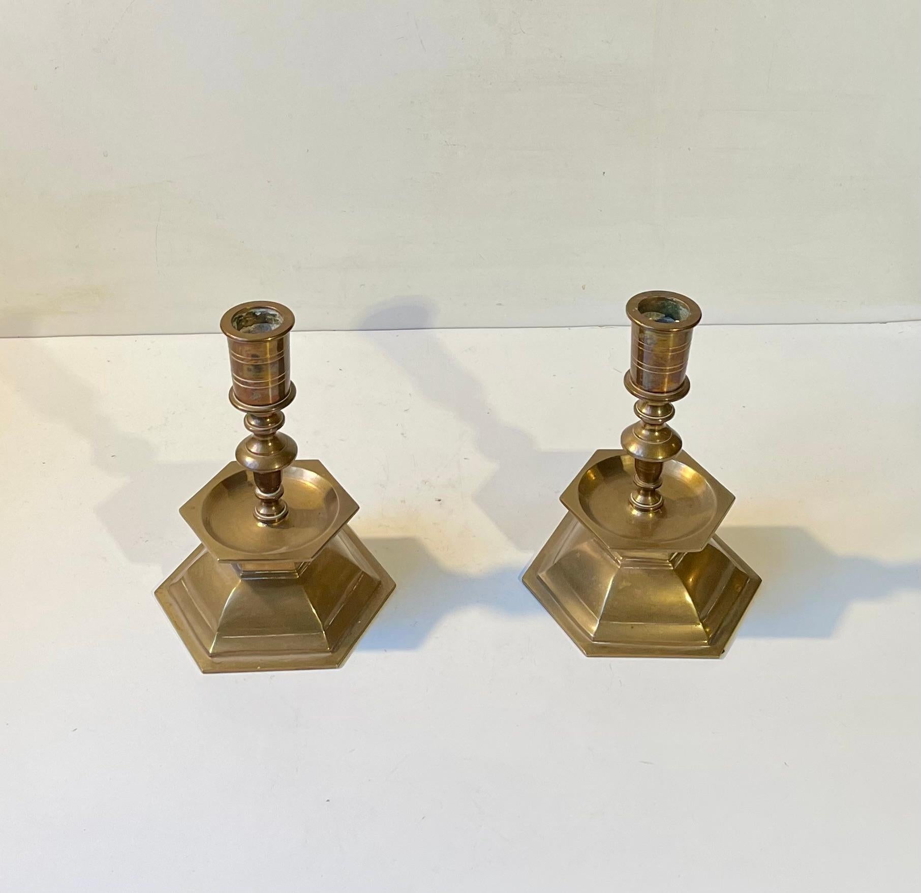 A pair of heavy altar candlesticks in brass. These came out of a Church Near Ribe in the western part of Denmark. The design is very plain despite their Baroque inspired shape. They have not been polished recently and the patina is overall and