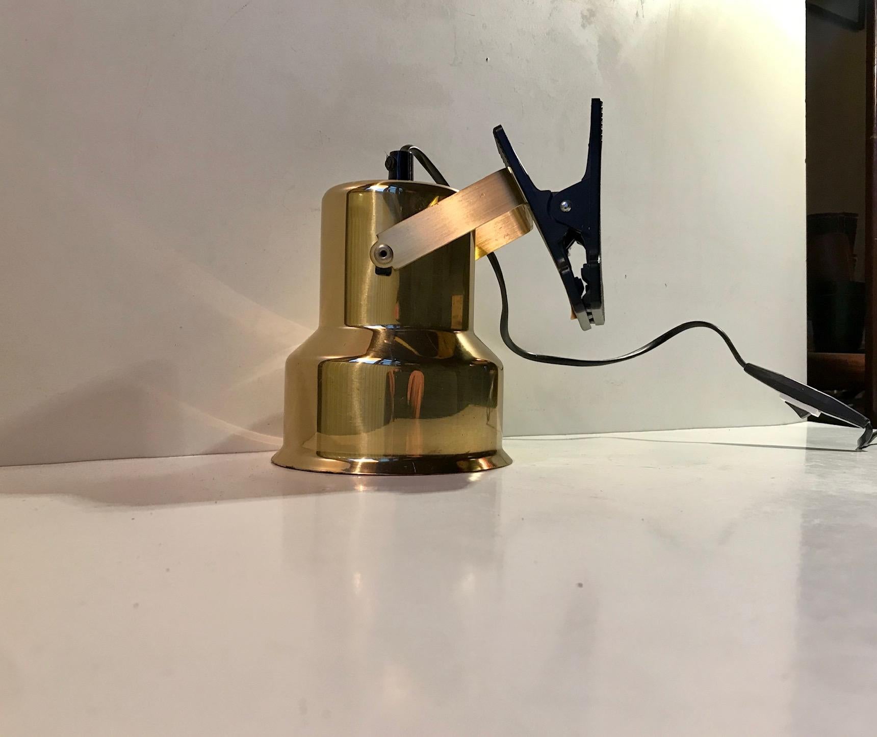 A fully adjustable clamp wall light with a shade composed of solid brass. Manufactured by ABO Metal Art in Denmark during the 1970s. The shade can be adjusted 270 degrees. The design is reminiscent to the style displayed by Anders Pehrson in his