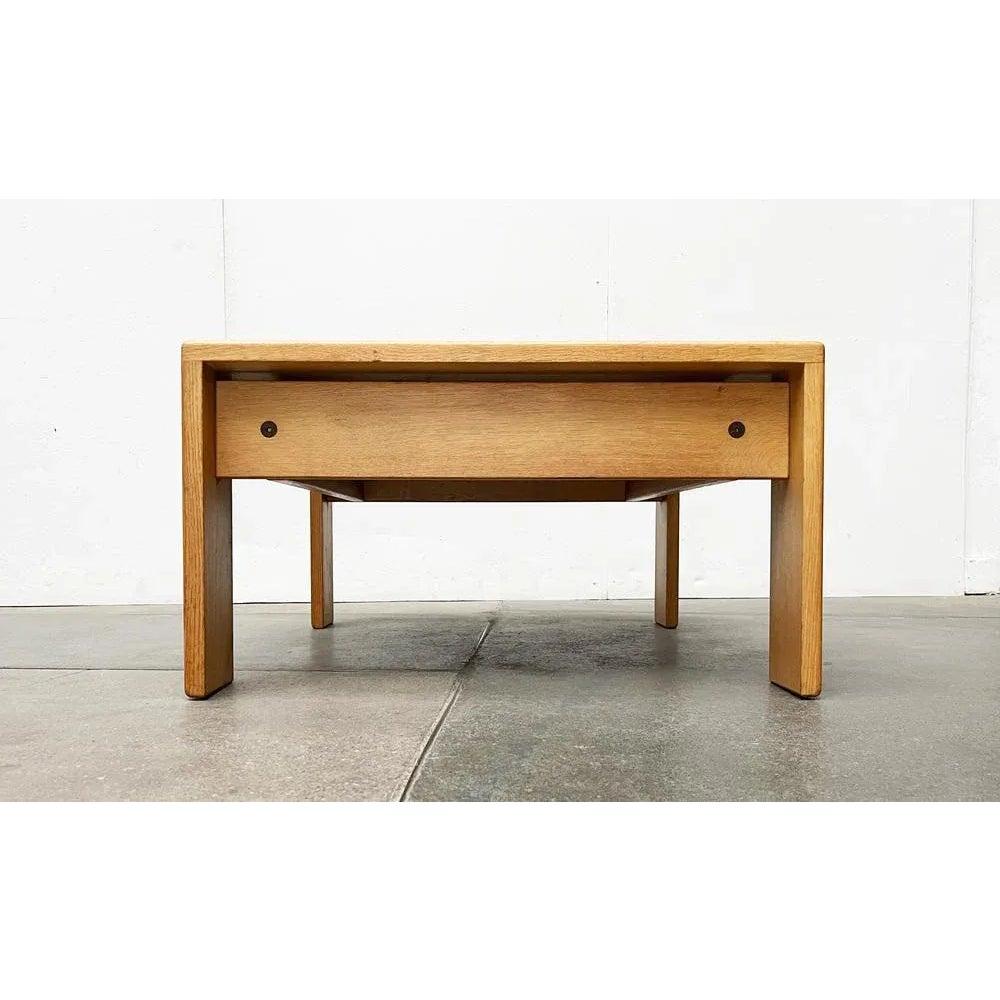 Heavy coffee table from Holstebro.

Simple coffee table from Denmark. The massive legs are U-shaped. The visible wooden connections at the corners are striking. The table top is inserted between the legs. The frame running under the table is
